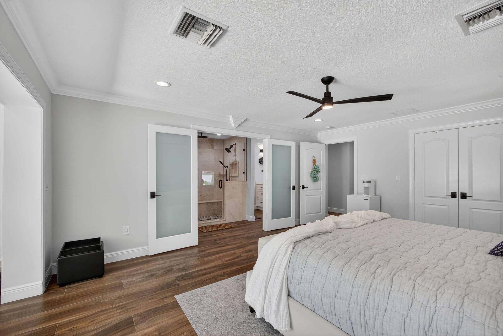 4628 Square Lake Drive, Palm Beach Gardens, FL 33418 Wood-finish flooring, double frosted-glass interior doors, modern ceiling fan, and crown molding
