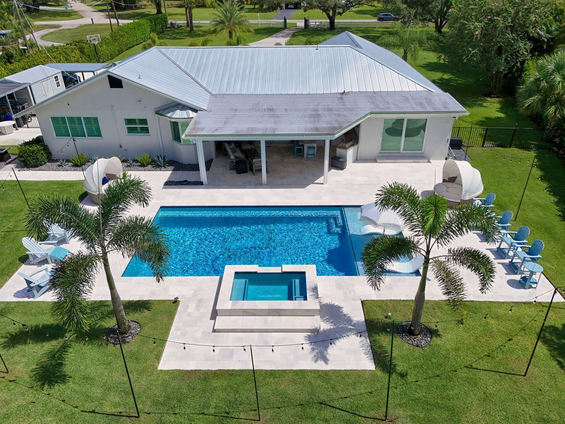 4628 Square Lake Drive, Palm Beach Gardens, FL 33418 Aerial view featuring a swimming pool, integrated spa, covered patio, metal roof, and stone-finish pool deck