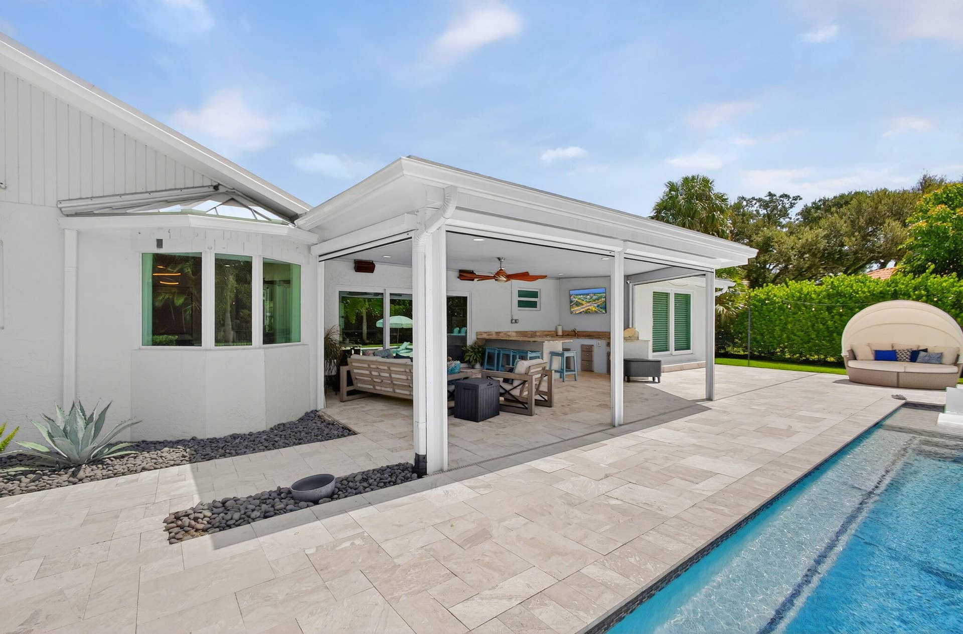 4628 Square Lake Drive, Palm Beach Gardens, FL 33418 Covered patio with integrated outdoor kitchen, stone-finish tile hardscaping, and swimming pool