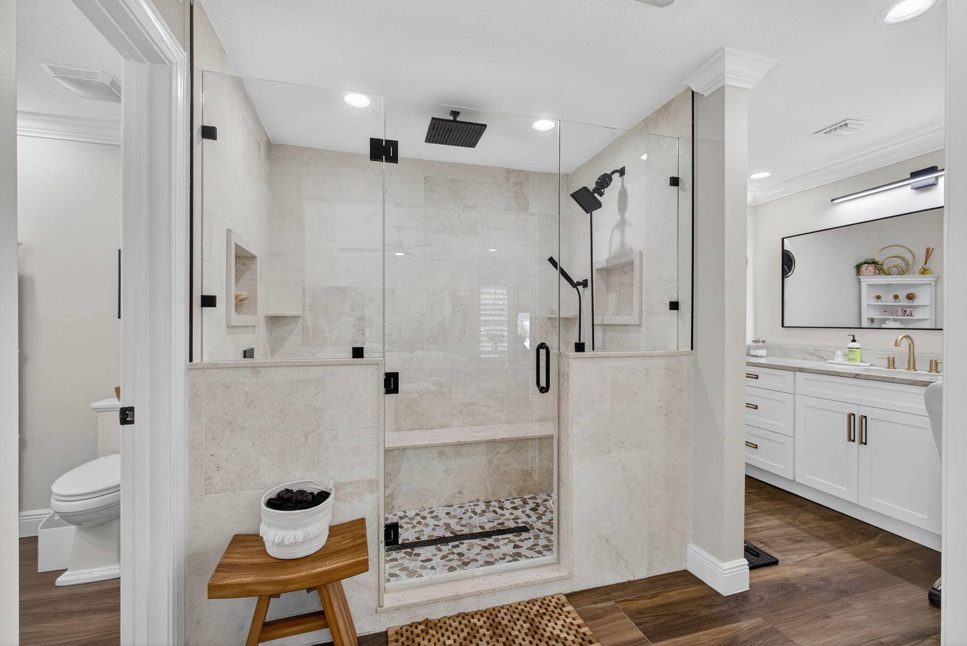 4628 Square Lake Drive, Palm Beach Gardens, FL 33418 Walk-in shower featuring a glass enclosure, built-in stone bench, overhead rainfall showerhead, and pebble-tile flooring