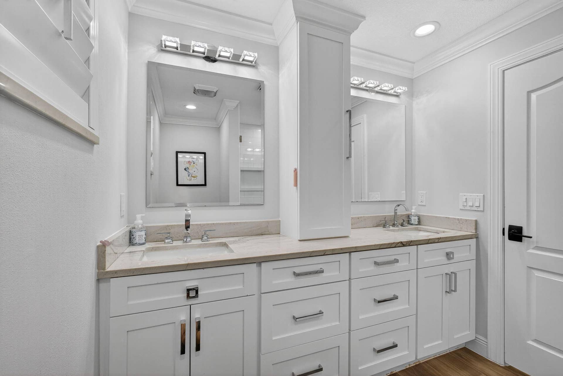 4628 Square Lake Drive, Palm Beach Gardens, FL 33418 Dual-sink vanity featuring white cabinetry, stone-finish countertops, undermount sinks, integrated linen tower, and contemporary metallic hardware