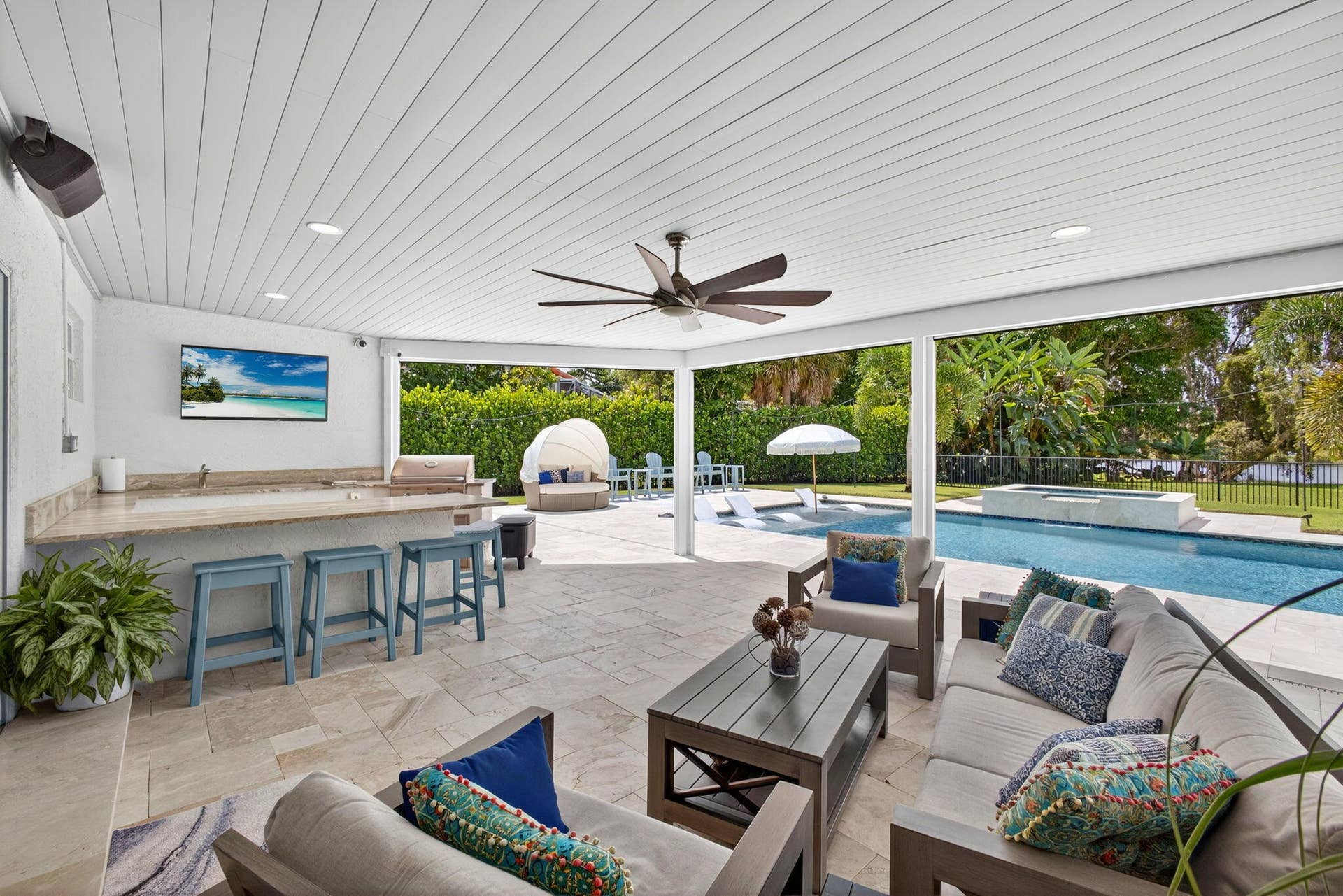 4628 Square Lake Drive, Palm Beach Gardens, FL 33418 Covered patio featuring stone-tile flooring, a built-in outdoor kitchen with a stone countertop, a ceiling fan, recessed lighting, and a swimming pool with an attached spa