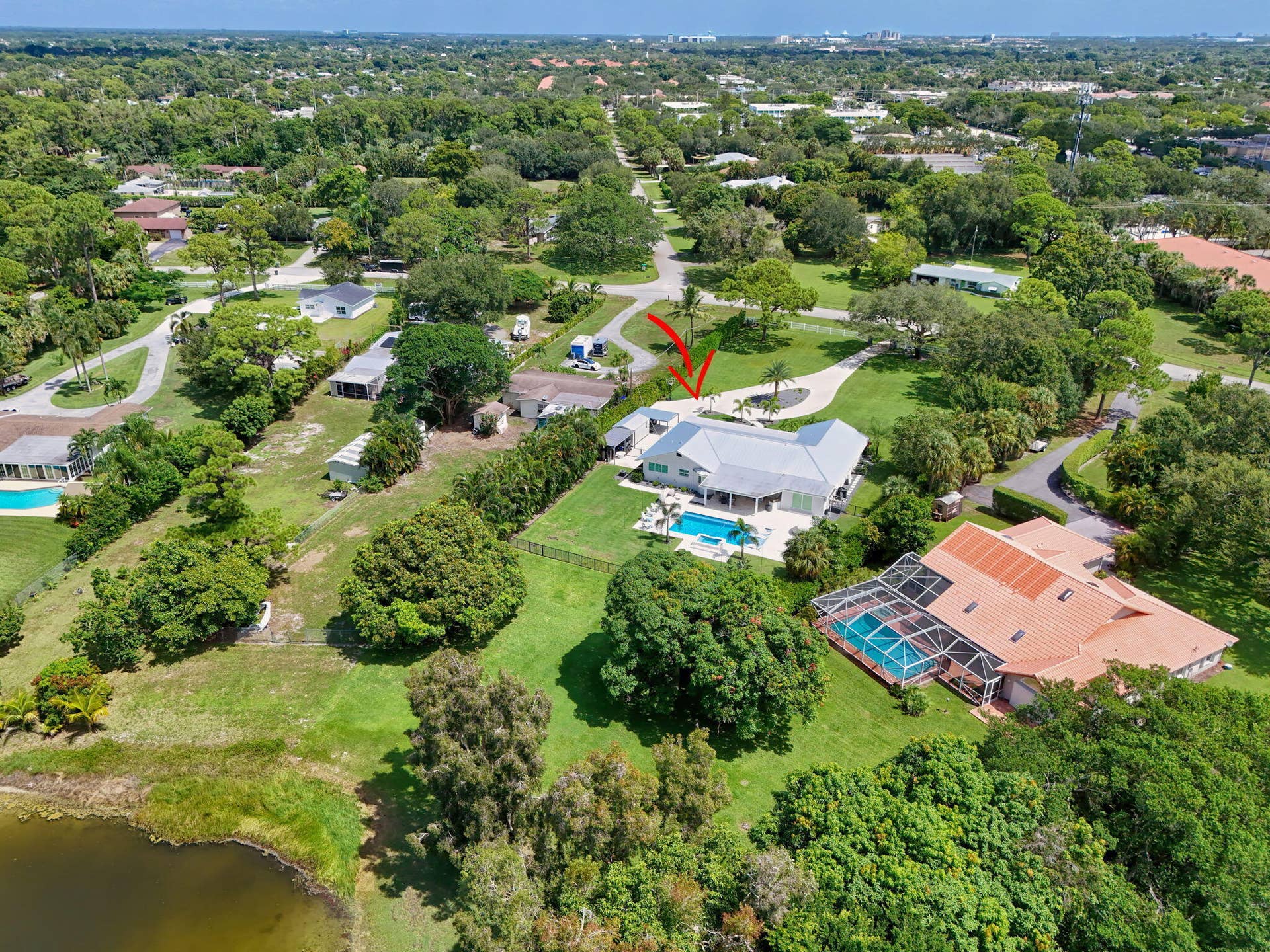 4628 Square Lake Drive, Palm Beach Gardens, FL 33418 Aerial perspective of a property featuring an expansive lot, a private swimming pool, a patio area, and a circular driveway