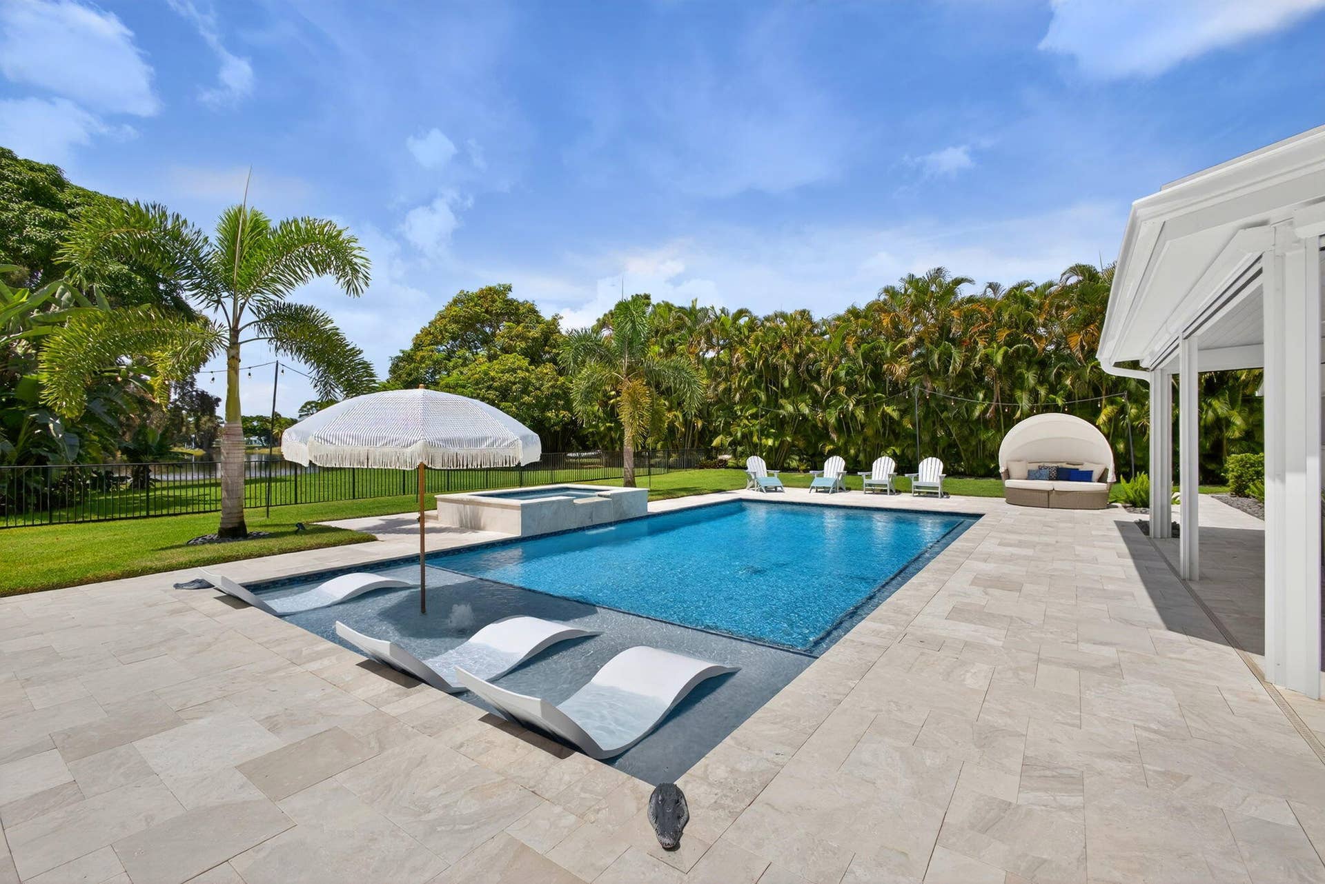 4628 Square Lake Drive, Palm Beach Gardens, FL 33418 In-ground swimming pool with a Baja shelf, integrated spa, and expansive stone-paver patio