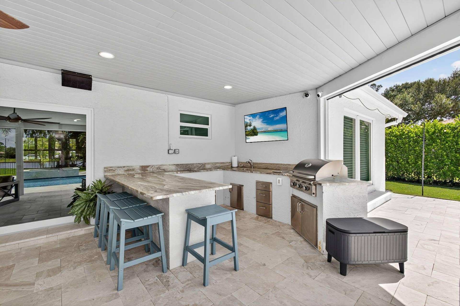 4628 Square Lake Drive, Palm Beach Gardens, FL 33418 Covered outdoor kitchen featuring stone-finish countertops, built-in stainless steel grill, recessed lighting, and stone paver flooring