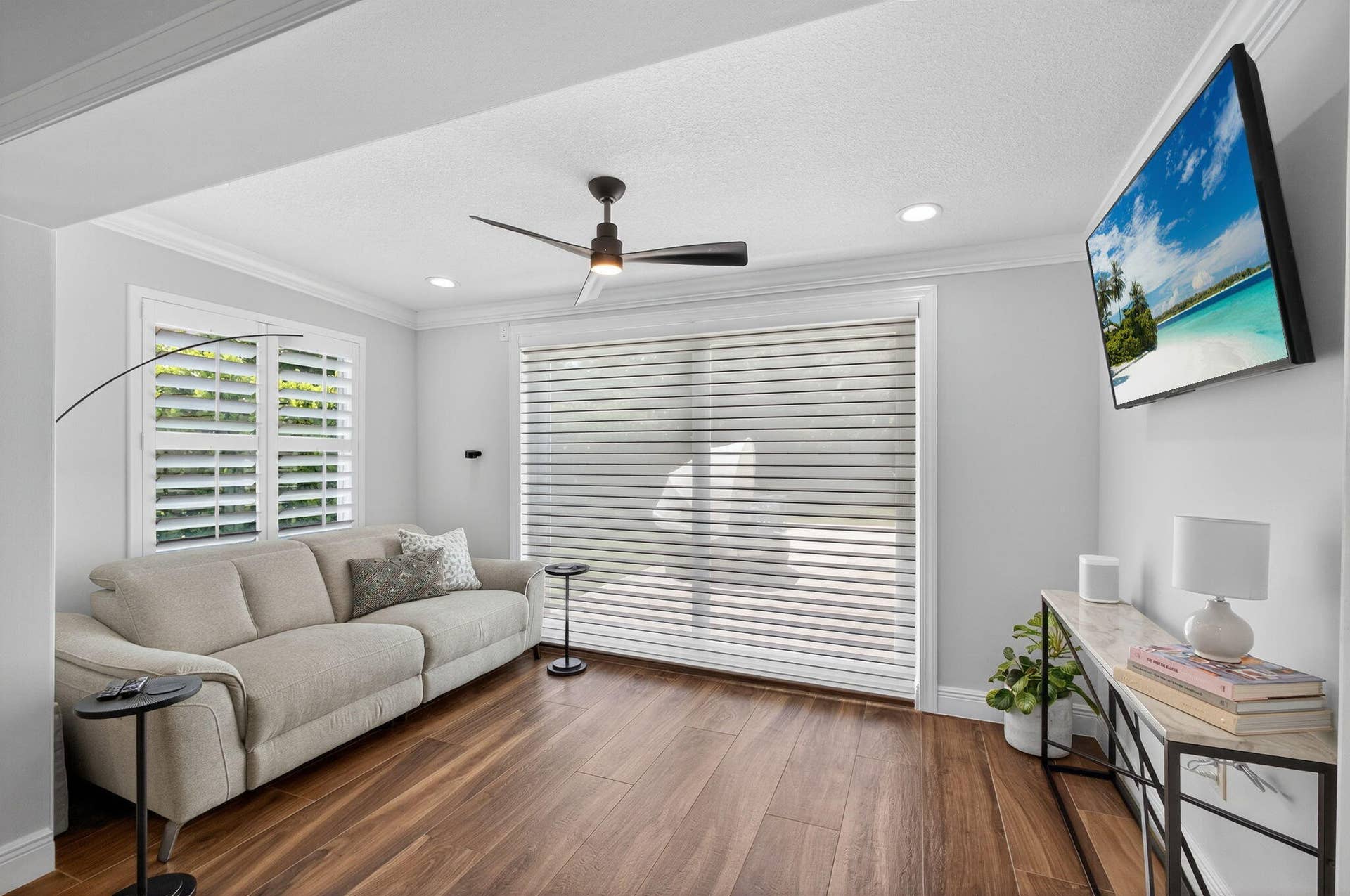 4628 Square Lake Drive, Palm Beach Gardens, FL 33418 Wood-finish flooring, recessed lighting, matte black ceiling fan, plantation shutters, and light-filtering horizontal window shades