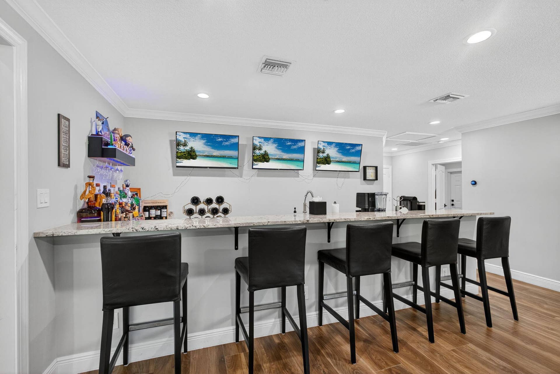 4628 Square Lake Drive, Palm Beach Gardens, FL 33418 Custom built-in bar area featuring a stone countertop, undermount sink, recessed lighting, and wood-finish flooring