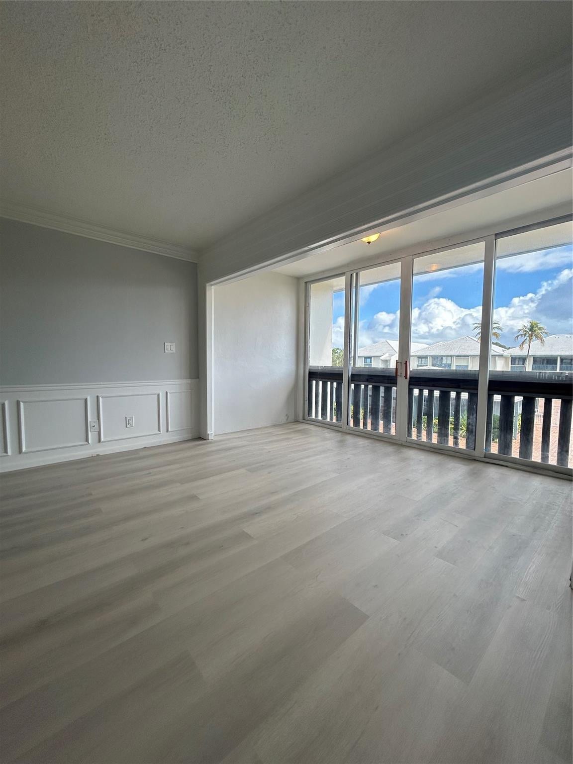 Balcony/ Florida Room/ Office space connected to Living/ Family room. Sliding doors were removed to connect the space for more usage. Window treatments / dividers can be added to separate the rooms.Brand new flooring just installed. Custom moldings (wainscoting) / wood work throughout the unit. View from balcony/ patio/ sun room looks over the St. Lucie River, pier, club house, pool, and shuffle board.