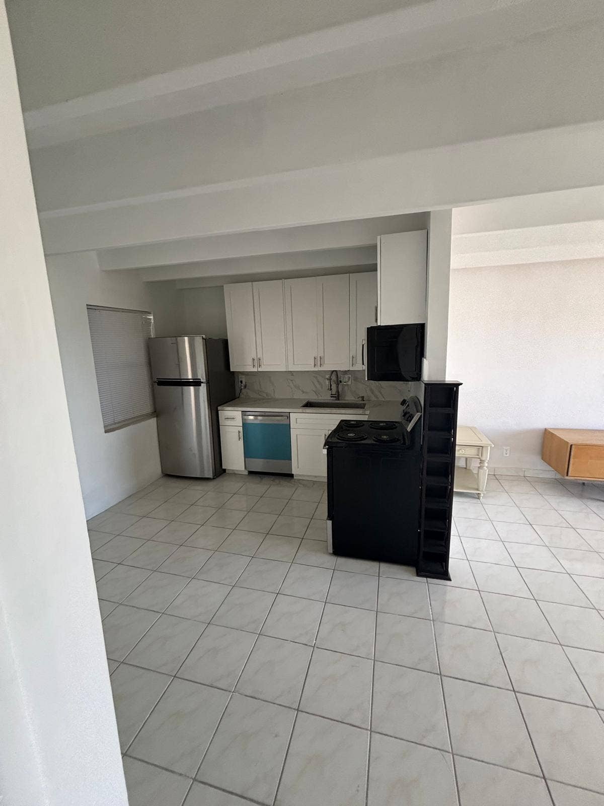4500 S Ocean Boulevard, #310, South Palm Beach, FL 33480 Kitchen featuring white cabinetry, tile flooring, stainless steel refrigerator, dishwasher, and stove