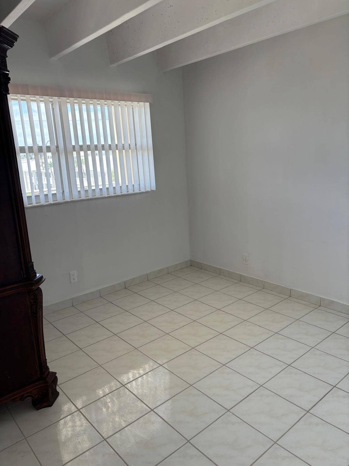 4500 S Ocean Boulevard, #310, South Palm Beach, FL 33480 Room featuring neutral tile flooring, exposed ceiling beams, and vertical window blinds