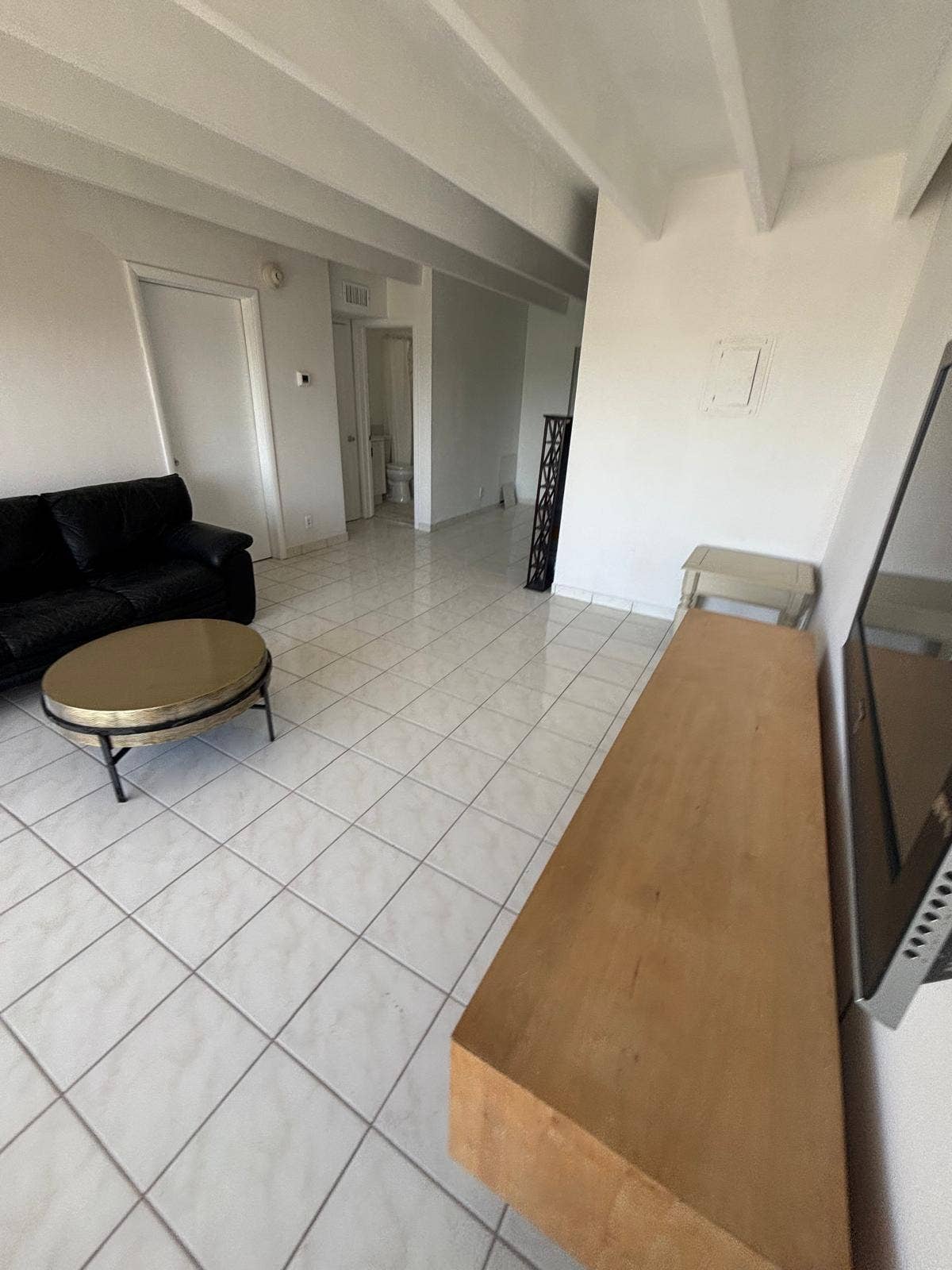 4500 S Ocean Boulevard, #310, South Palm Beach, FL 33480 Interior featuring white ceramic tile flooring, exposed ceiling beams, and neutral wall tones