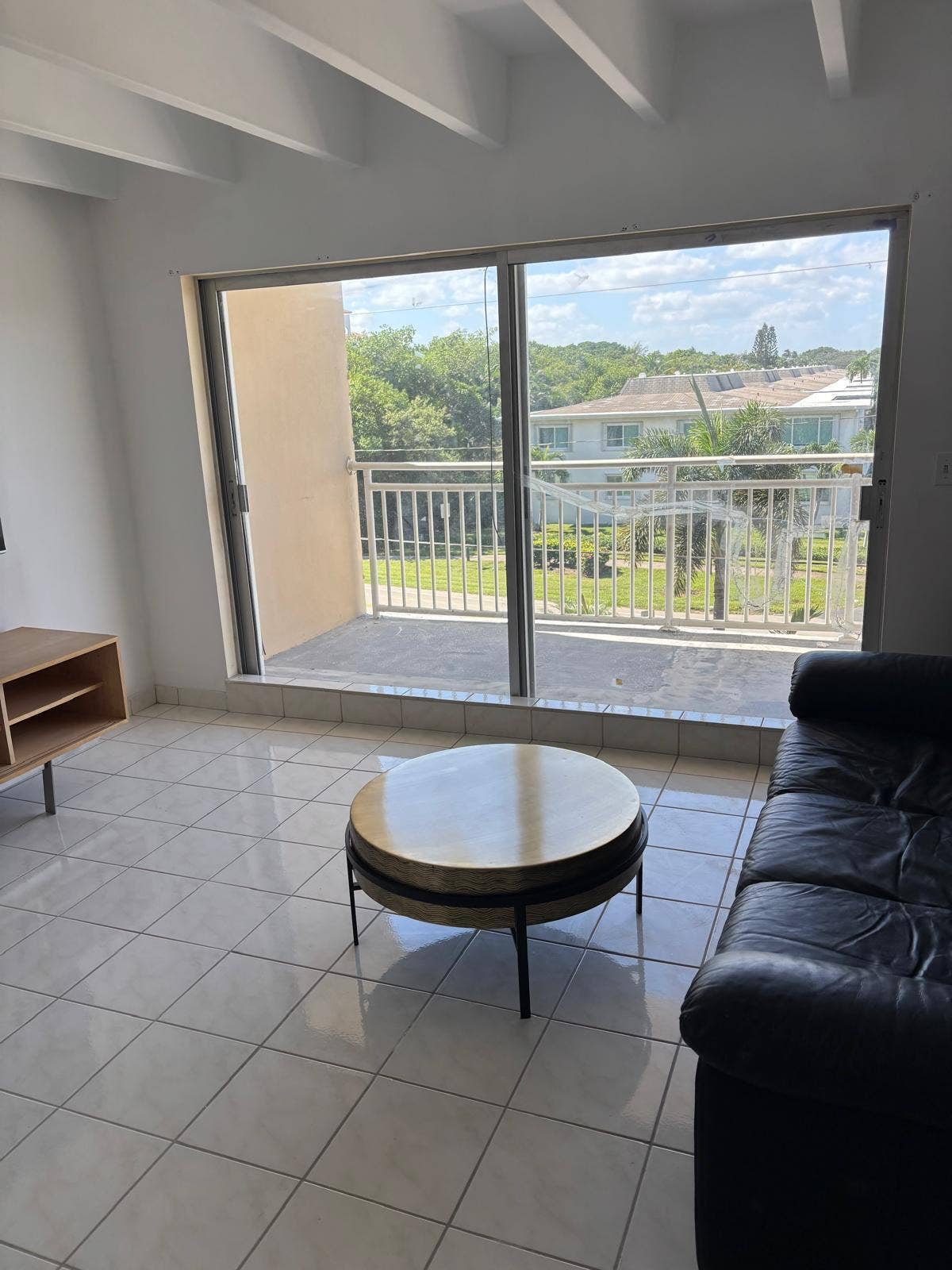 4500 S Ocean Boulevard, #310, South Palm Beach, FL 33480 Large sliding glass doors opening to a private balcony with metal railings, tile flooring, and exposed ceiling beams