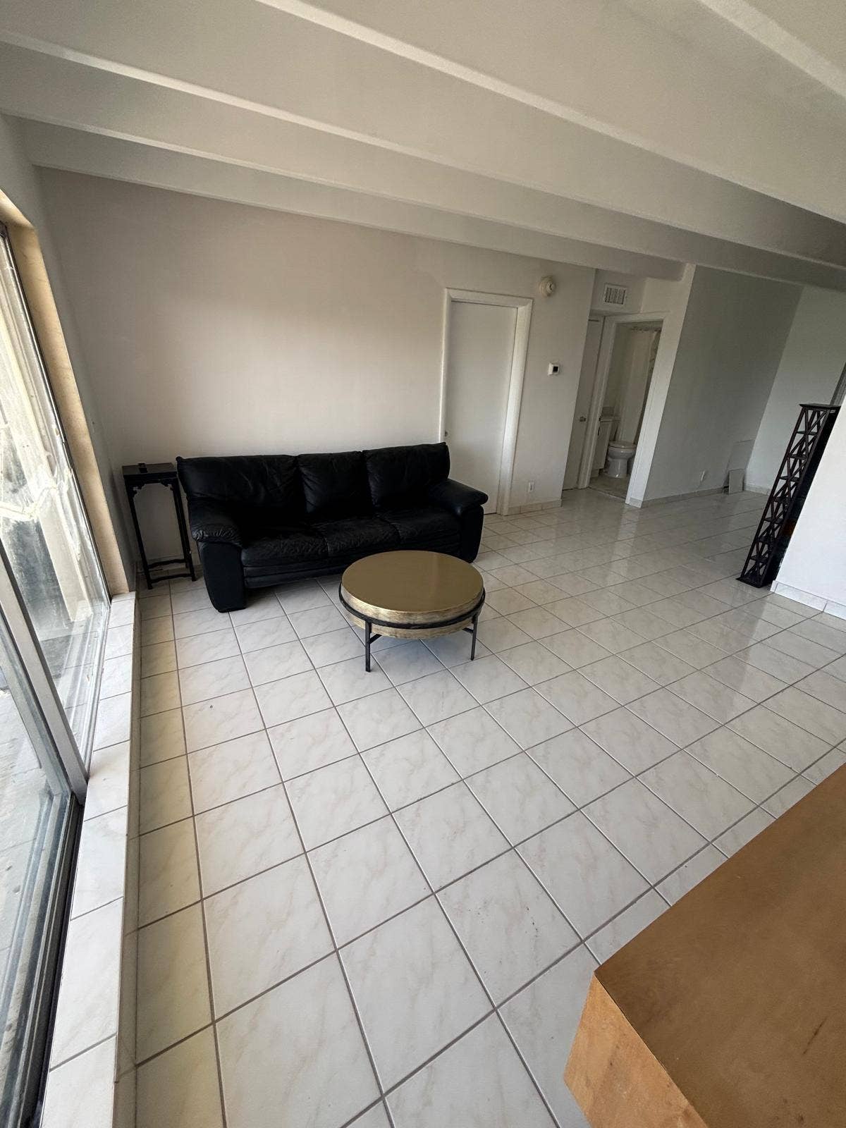 4500 S Ocean Boulevard, #310, South Palm Beach, FL 33480 Large-format tile flooring, exposed structural ceiling beams, and floor-to-ceiling glass sliding doors