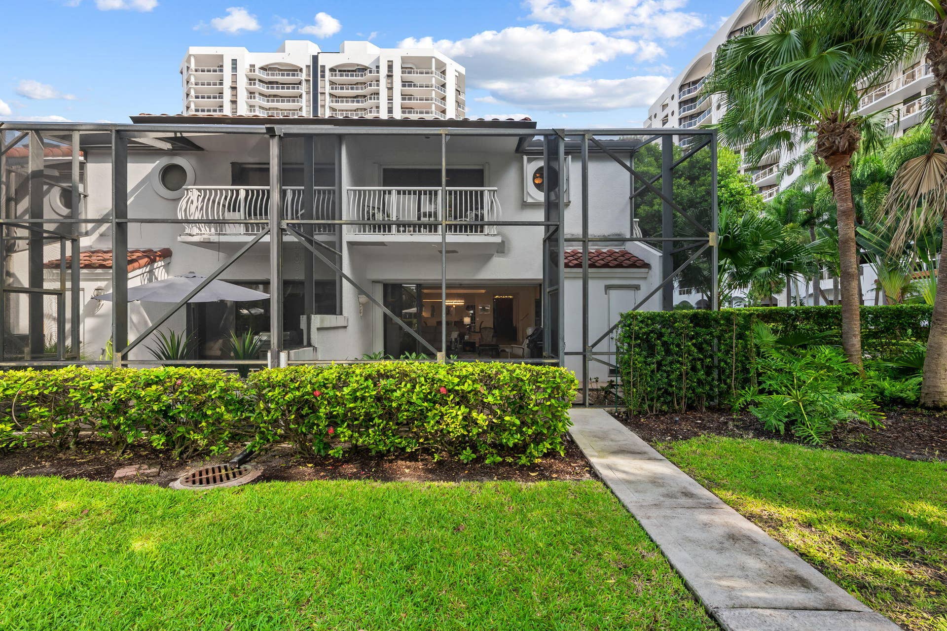 Screened lanai, concrete walkway and manicured landscaping