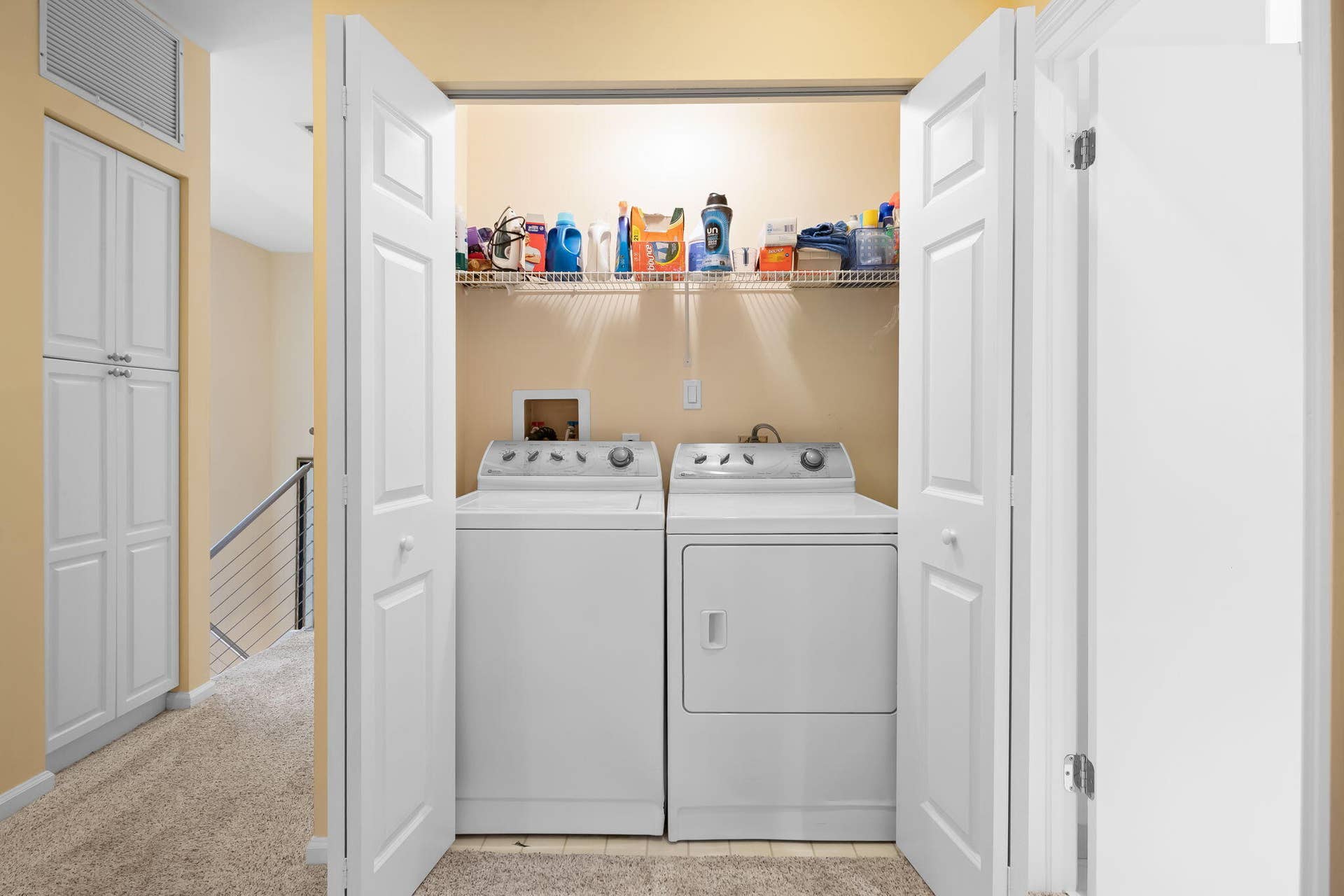 Laundry closet featuring dual-folding doors, wire shelving