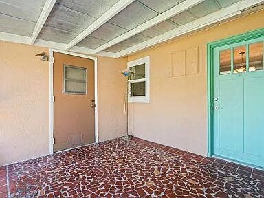1404 Binney Drive, Fort Pierce, FL 34949 Screened patio. Turquoise Door is back door entry to left side unit. Brown door is to joined laundry area.