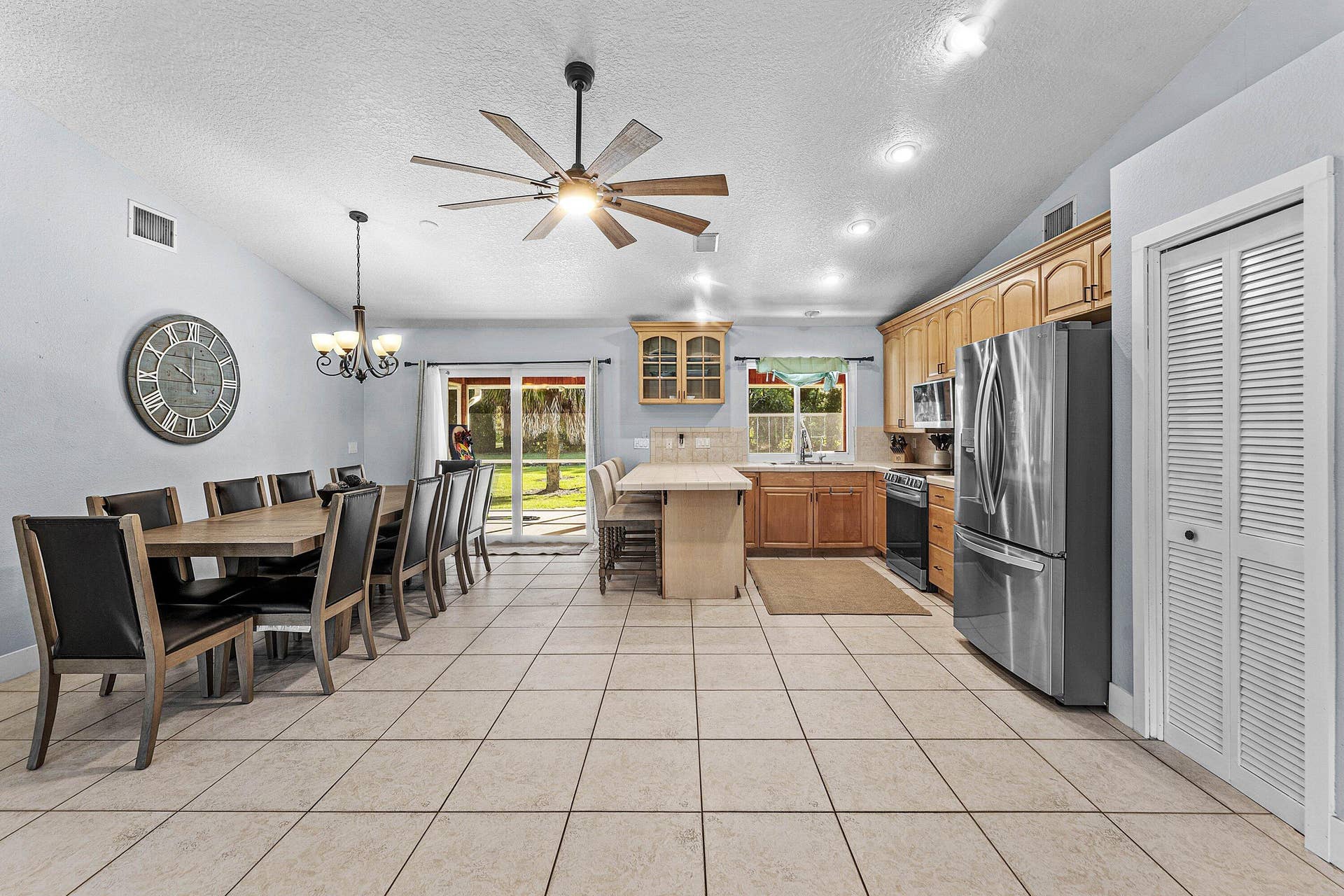 Kitchen featuring wood cabinetry, tiled island, stainless steel refrigerator, recessed lighting, and tile flooring