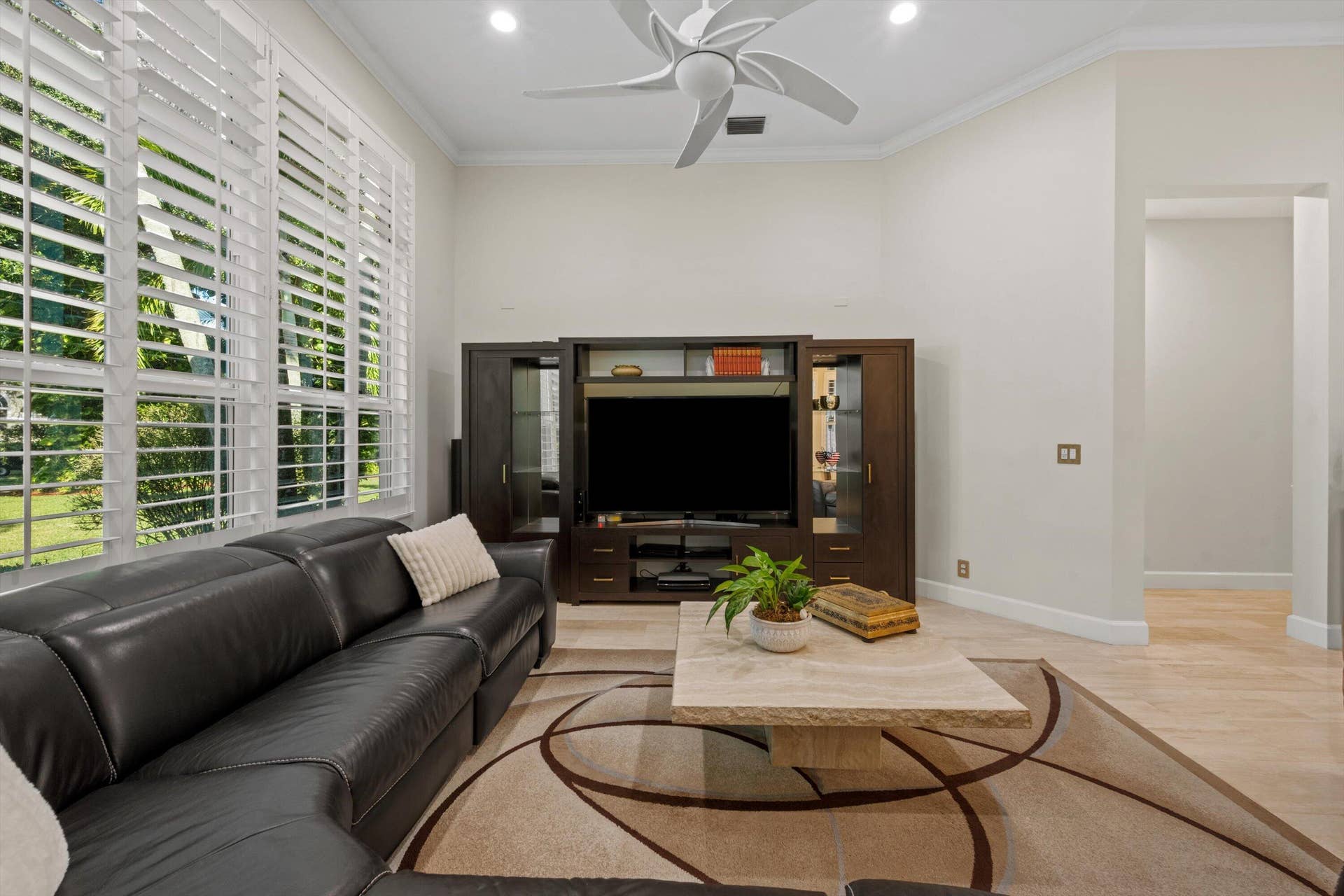 High ceilings with recessed lighting, integrated ceiling fan, plantation shutters, and large-format tile flooring