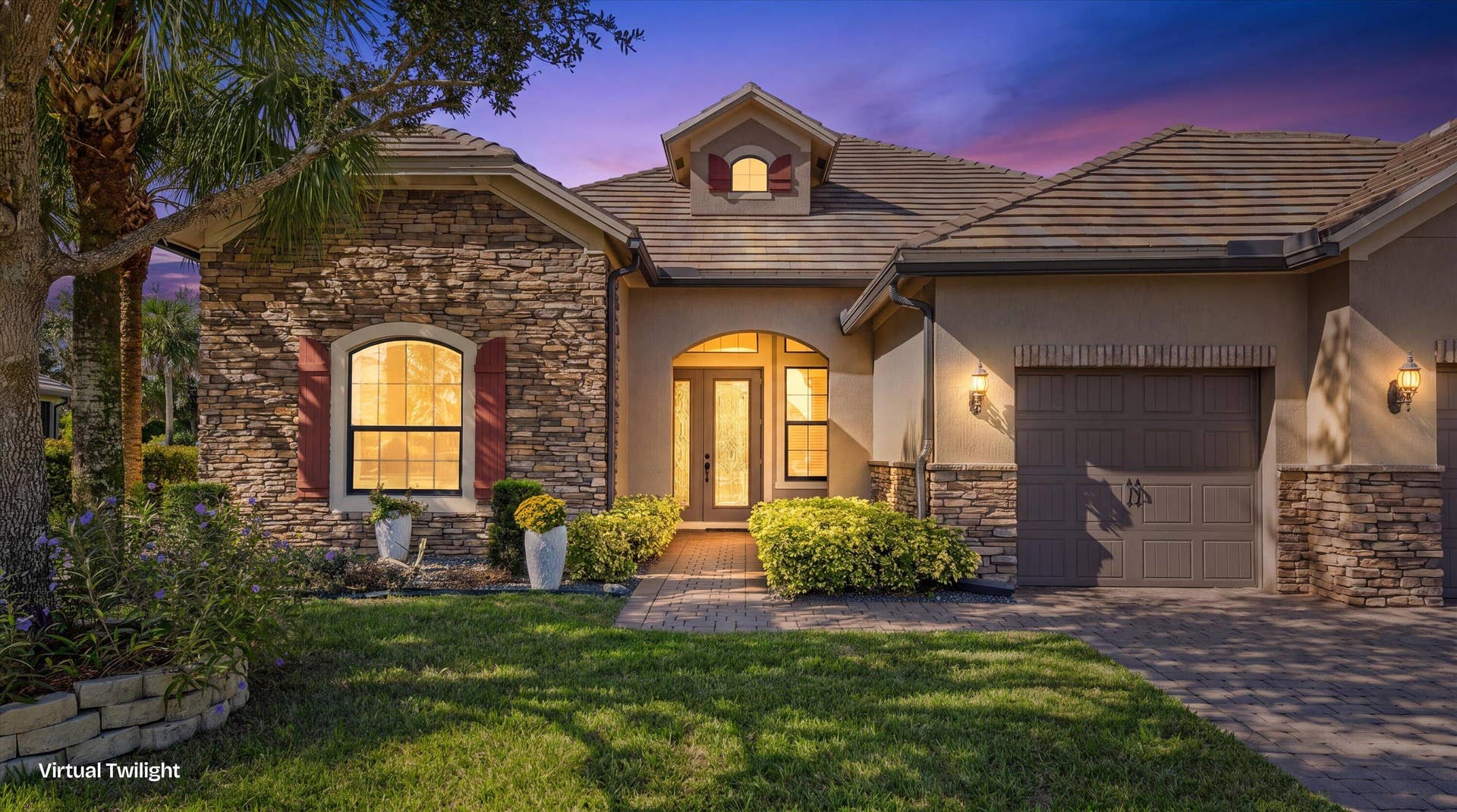 Exterior featuring stone veneer siding, tile roof, arched entryway with double doors, and paved driveway