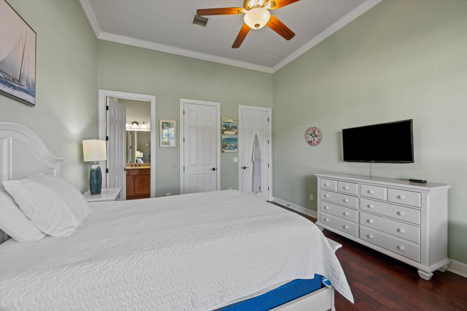High ceilings featuring crown molding, wood-finish flooring, and a ceiling fan