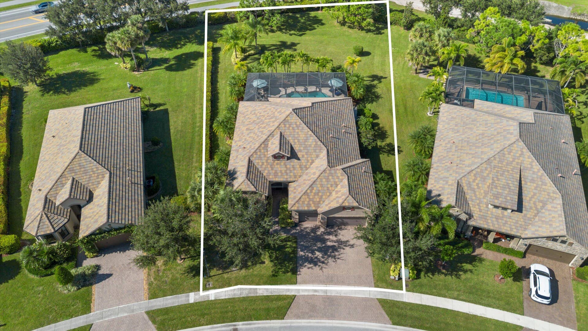 Aerial perspective featuring a paved driveway, a multi-gabled roof, an enclosed screened-in pool, and extensive lawn landscaping