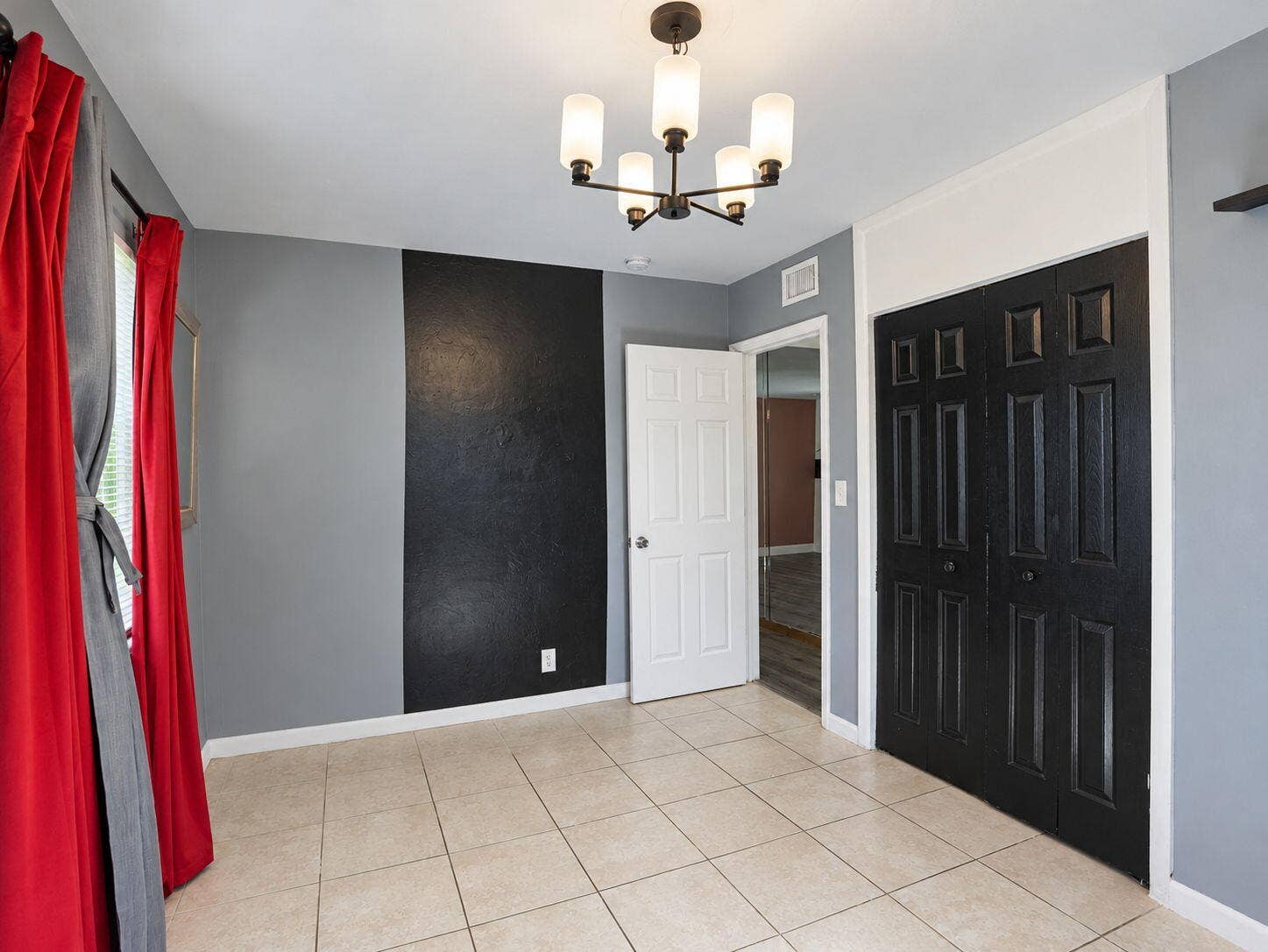 1805 NW 13TH Court, Fort Lauderdale, FL 33311 Ceramic tile flooring, five-light chandelier with frosted glass shades, and black six-panel closet doors