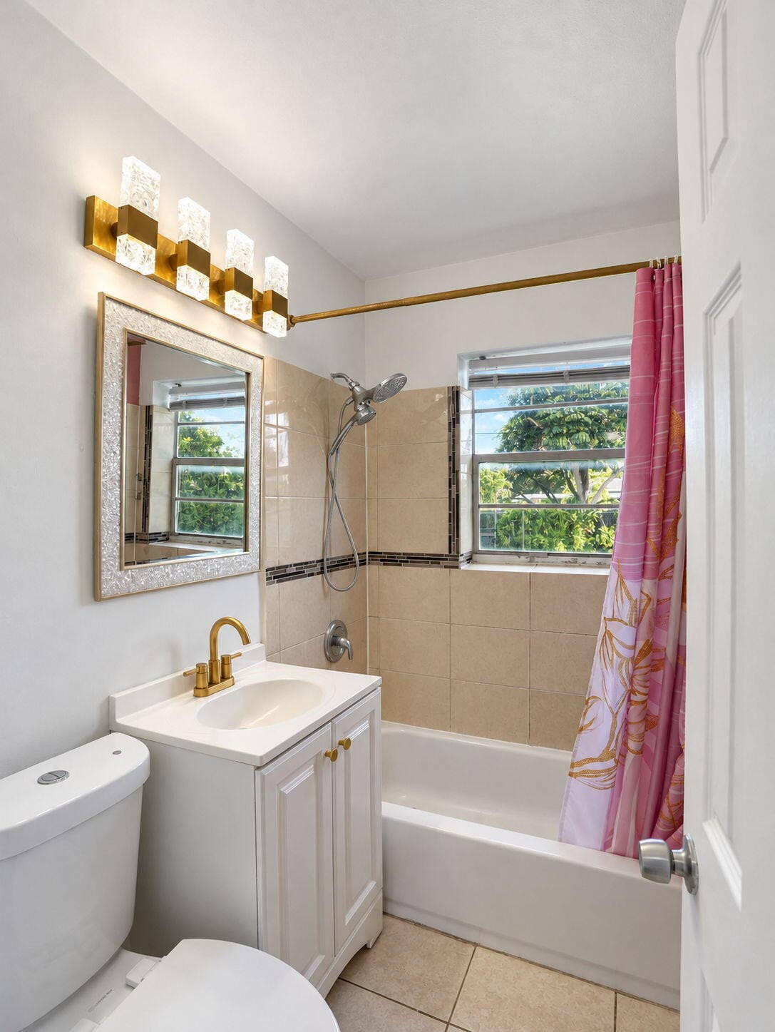 1805 NW 13TH Court, Fort Lauderdale, FL 33311 Bathroom featuring a white vanity with brass-finish faucet, multi-light fixture, combo shower/tub