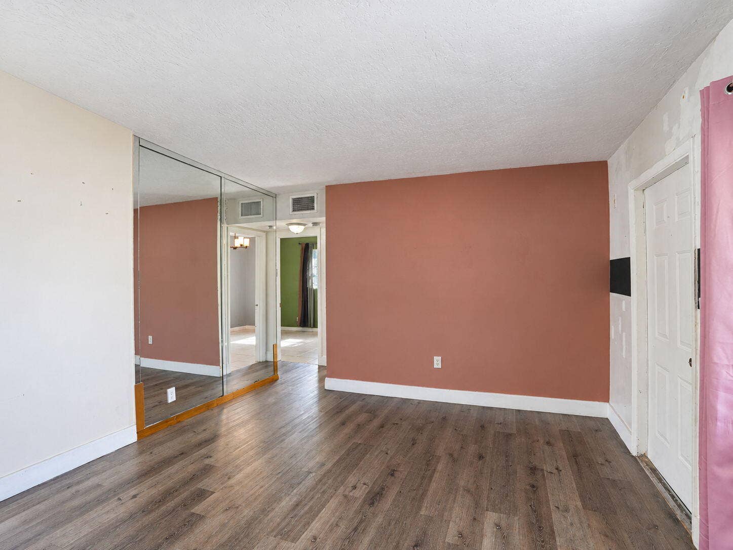 1805 NW 13TH Court, Fort Lauderdale, FL 33311 Living Room featuring wood-finish flooring, floor-to-ceiling mirrored wall paneling