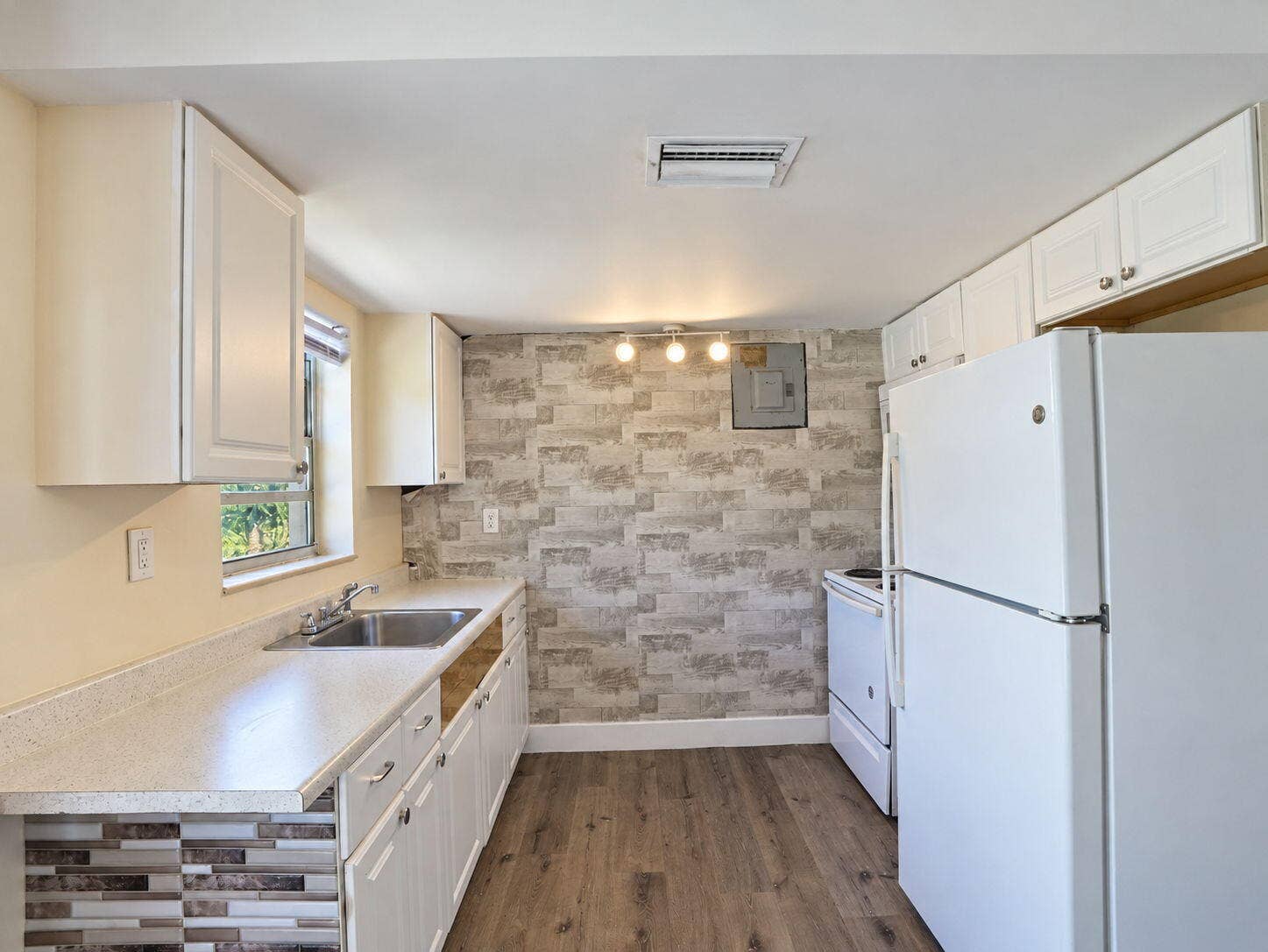 1805 NW 13TH Court, Fort Lauderdale, FL 33311 Kitchen featuring white cabinetry, wood-finish flooring,
