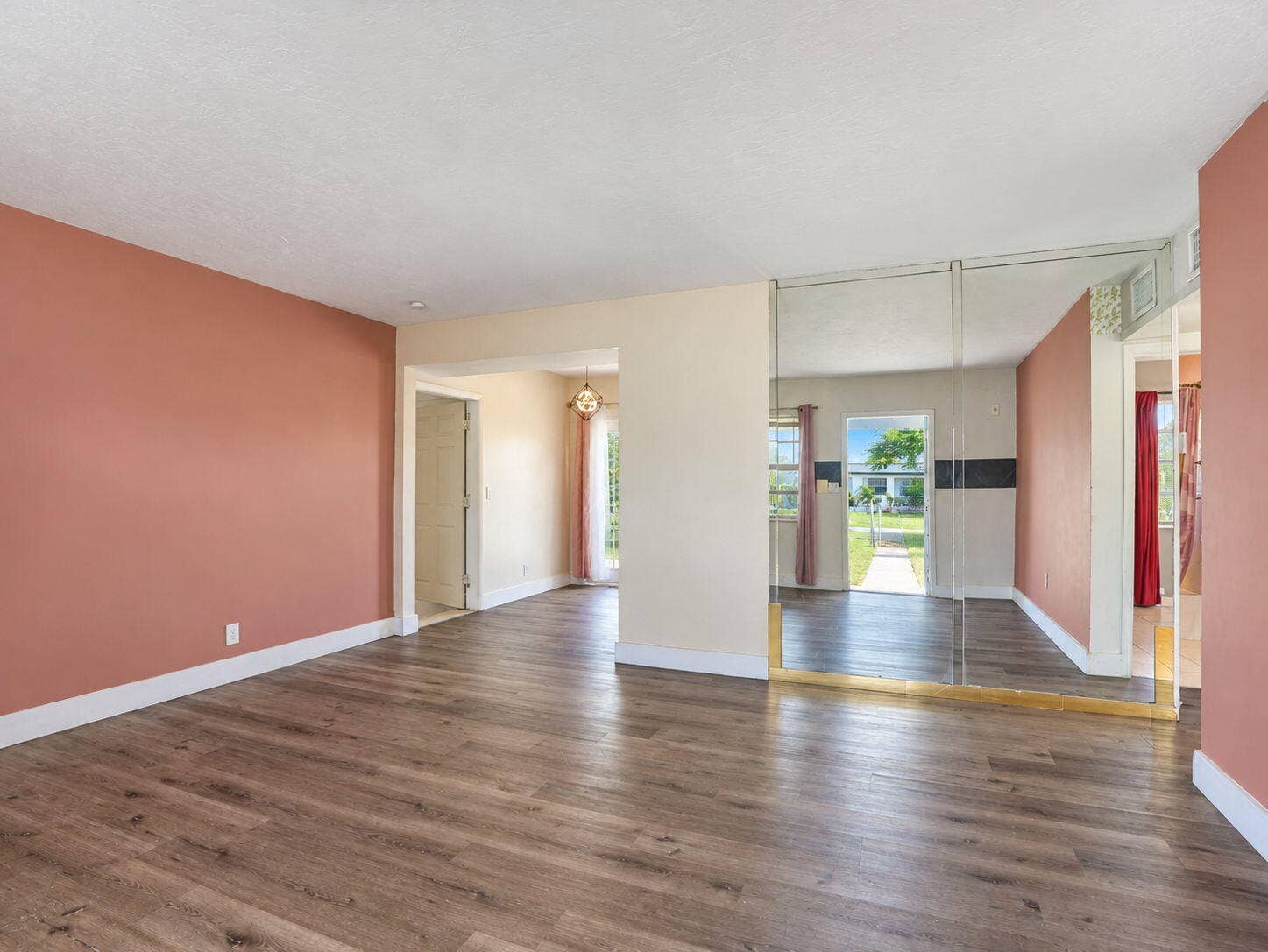 1805 NW 13TH Court, Fort Lauderdale, FL 33311 Living Room featuring wood-finish flooring, floor-to-ceiling mirrored wall paneling