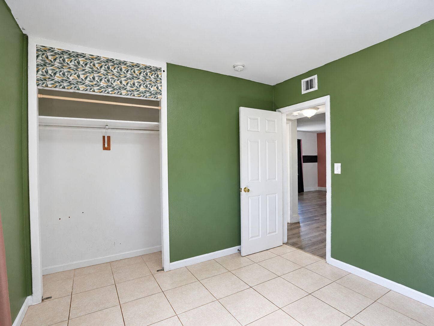 1805 NW 13TH Court, Fort Lauderdale, FL 33311 Bedroom interior featuring neutral tile flooring, six-panel interior door, and built-in closet with decorative valance