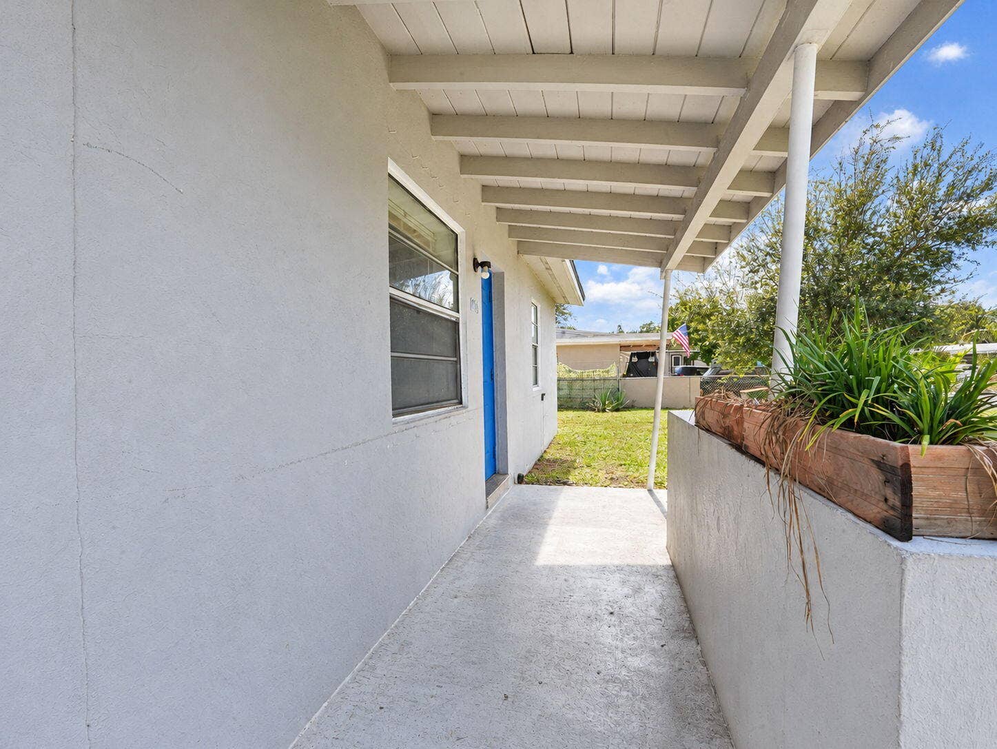 1805 NW 13TH Court, Fort Lauderdale, FL 33311 Covered exterior porch featuring a concrete floor, painted stucco siding, and a built-in stucco planter