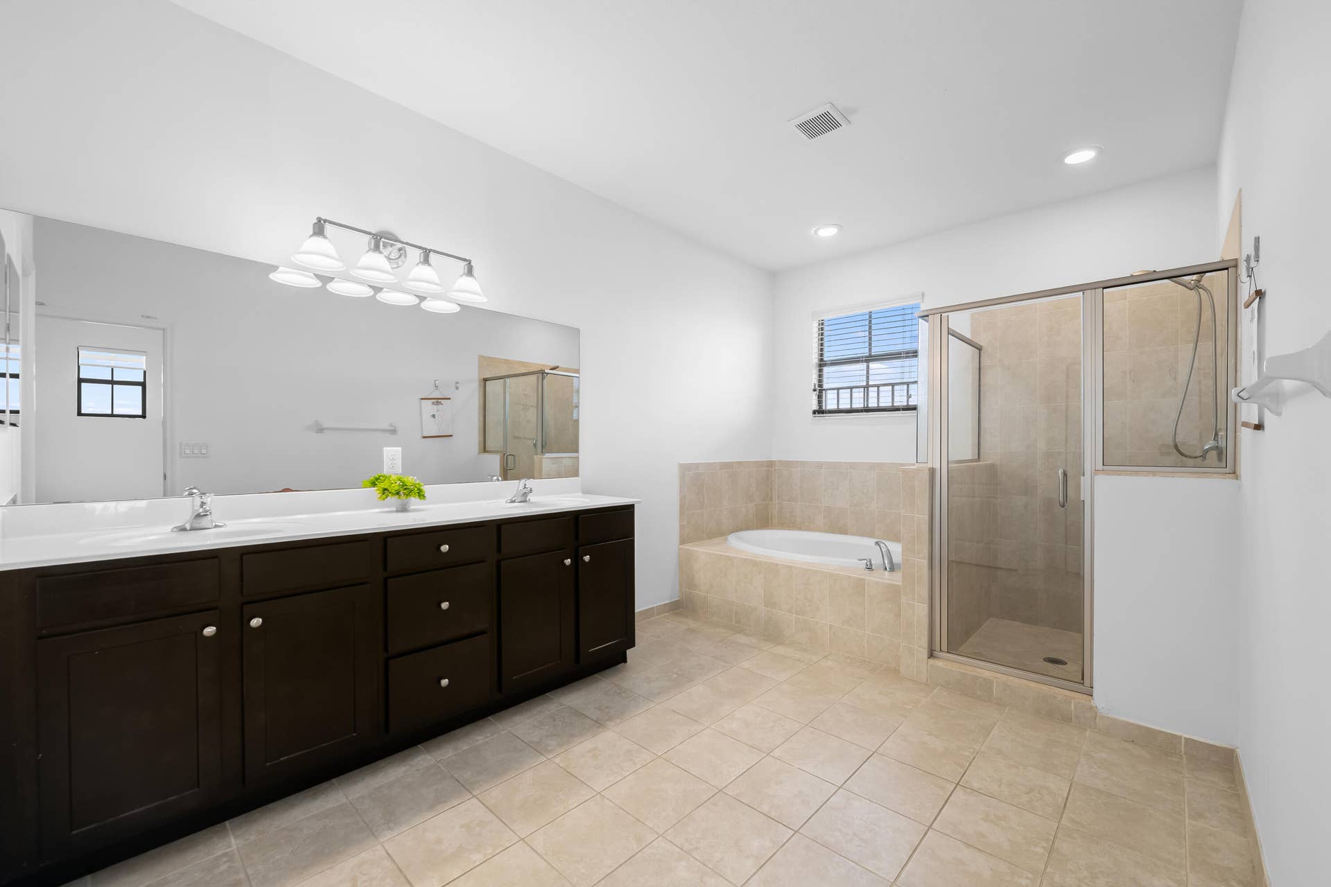 Expansive primary bathroom offering an abundance of space and spa-like atmosphere
