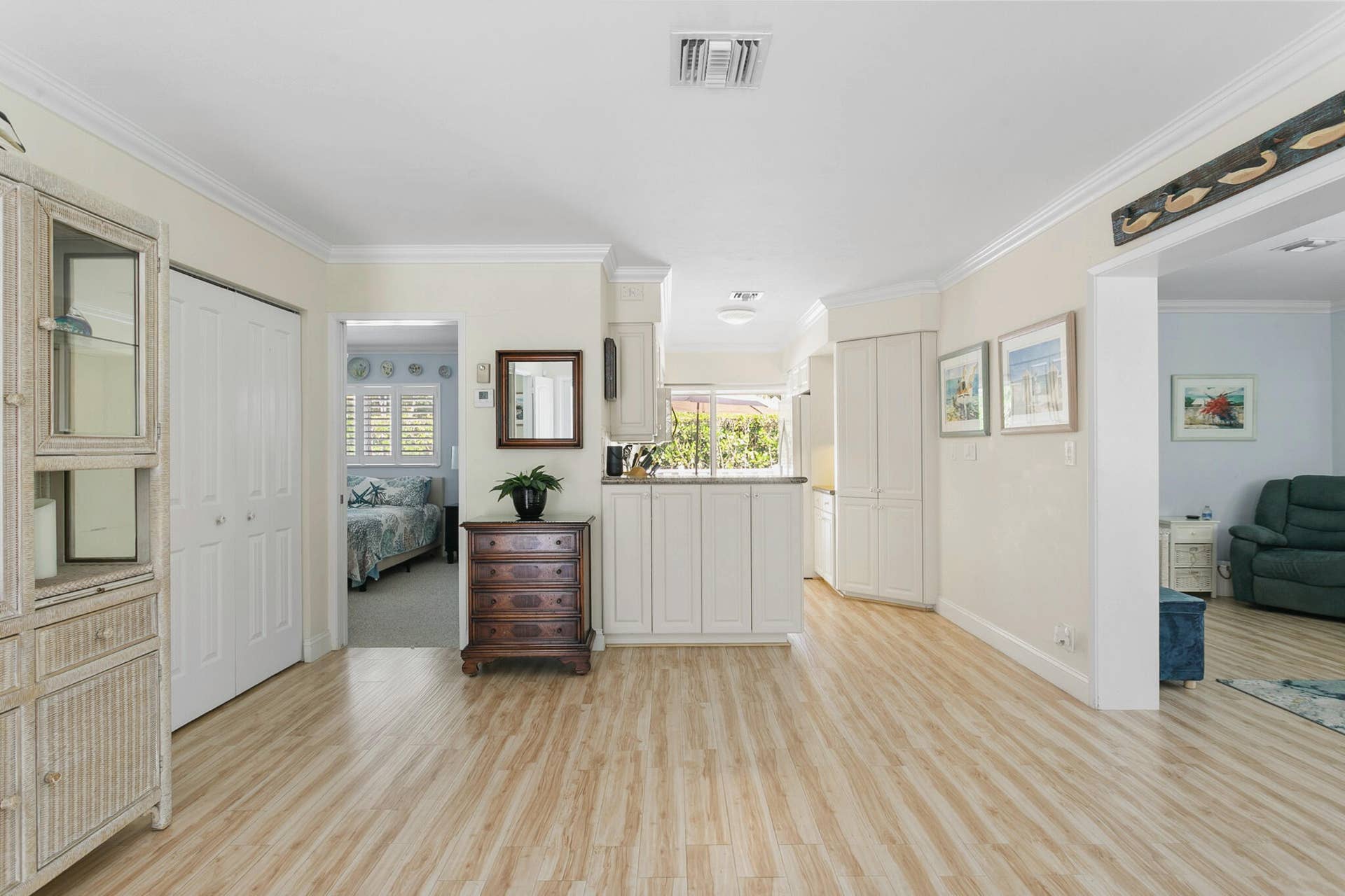 2607 SE 21ST Street, Fort Lauderdale, FL 33316 Open-concept interior featuring light-toned wood-finish flooring, white cabinetry with crown molding, and recessed lighting