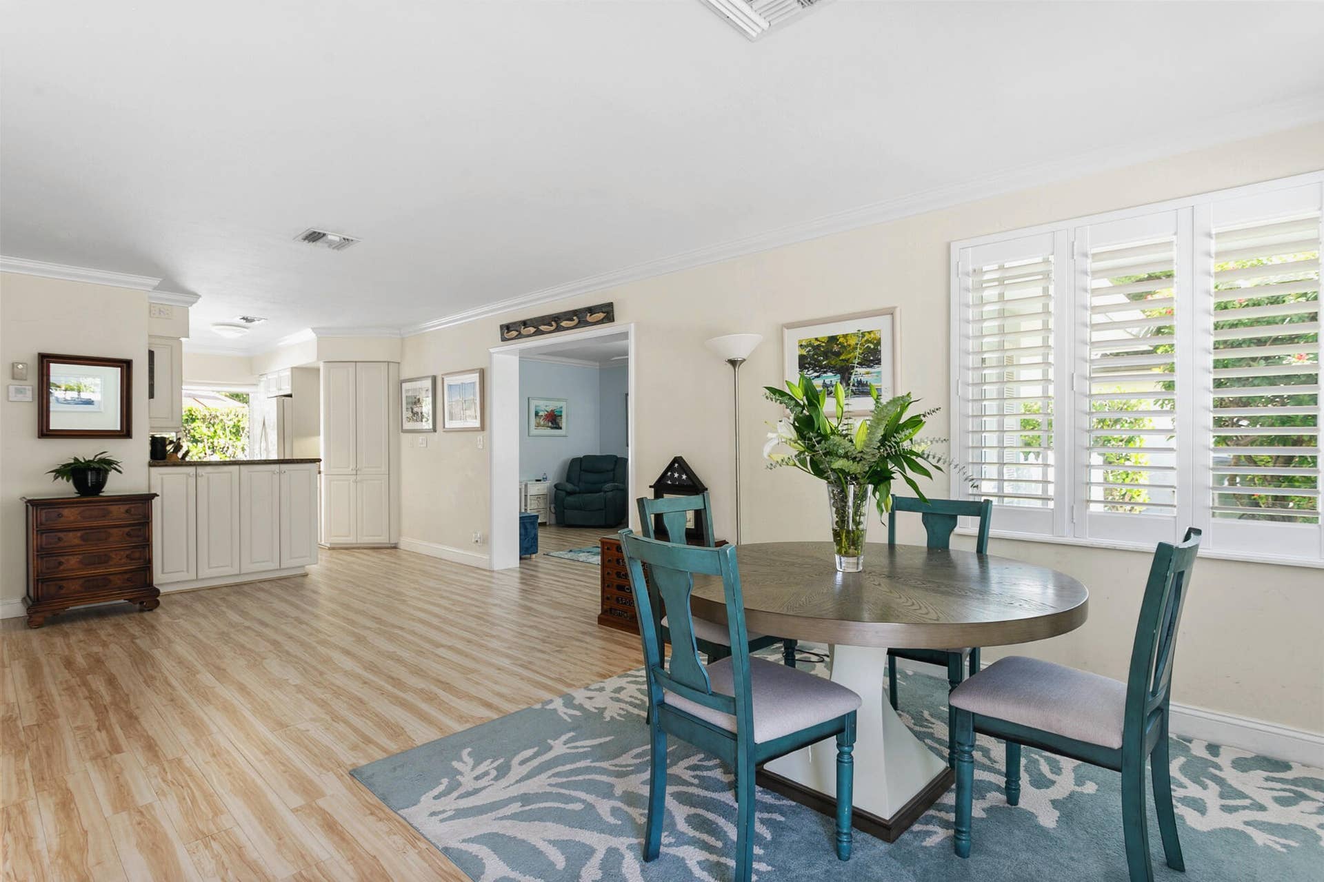 2607 SE 21ST Street, Fort Lauderdale, FL 33316 Open-concept interior featuring light-toned wood-finish flooring, plantation shutters and crown molding