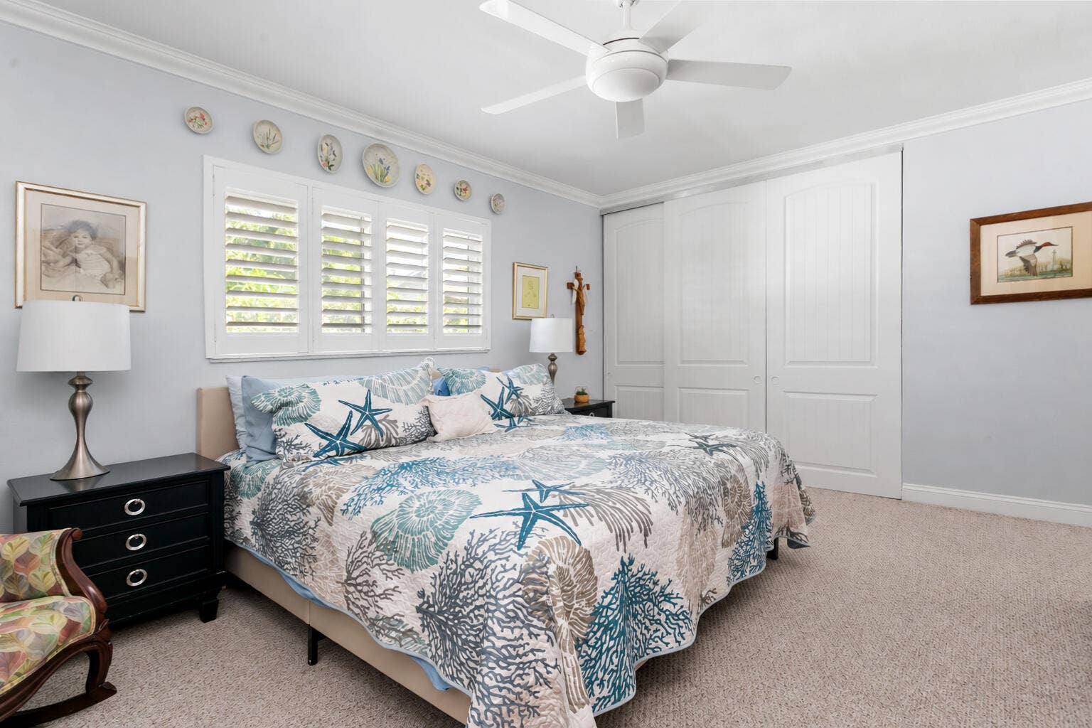 2607 SE 21ST Street, Fort Lauderdale, FL 33316 Bedroom featuring white plantation shutters, neutral carpeting, ceiling fan, and floor-to-ceiling sliding closet doors with paneled detailing