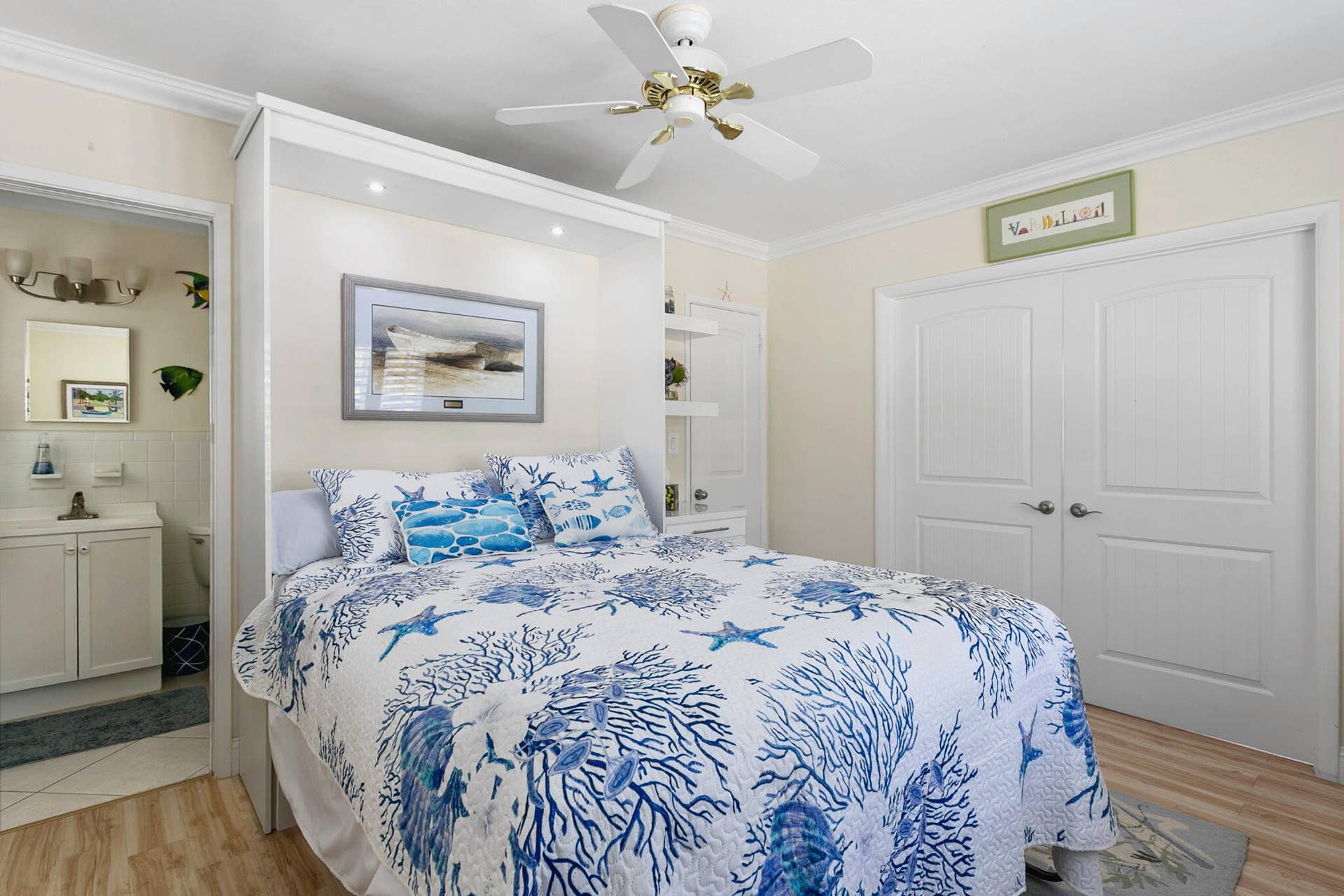 2607 SE 21ST Street, Fort Lauderdale, FL 33316 Murphy bed with integrated lighting, double-door closet, crown molding, white ceiling fan, and wood-finish flooring