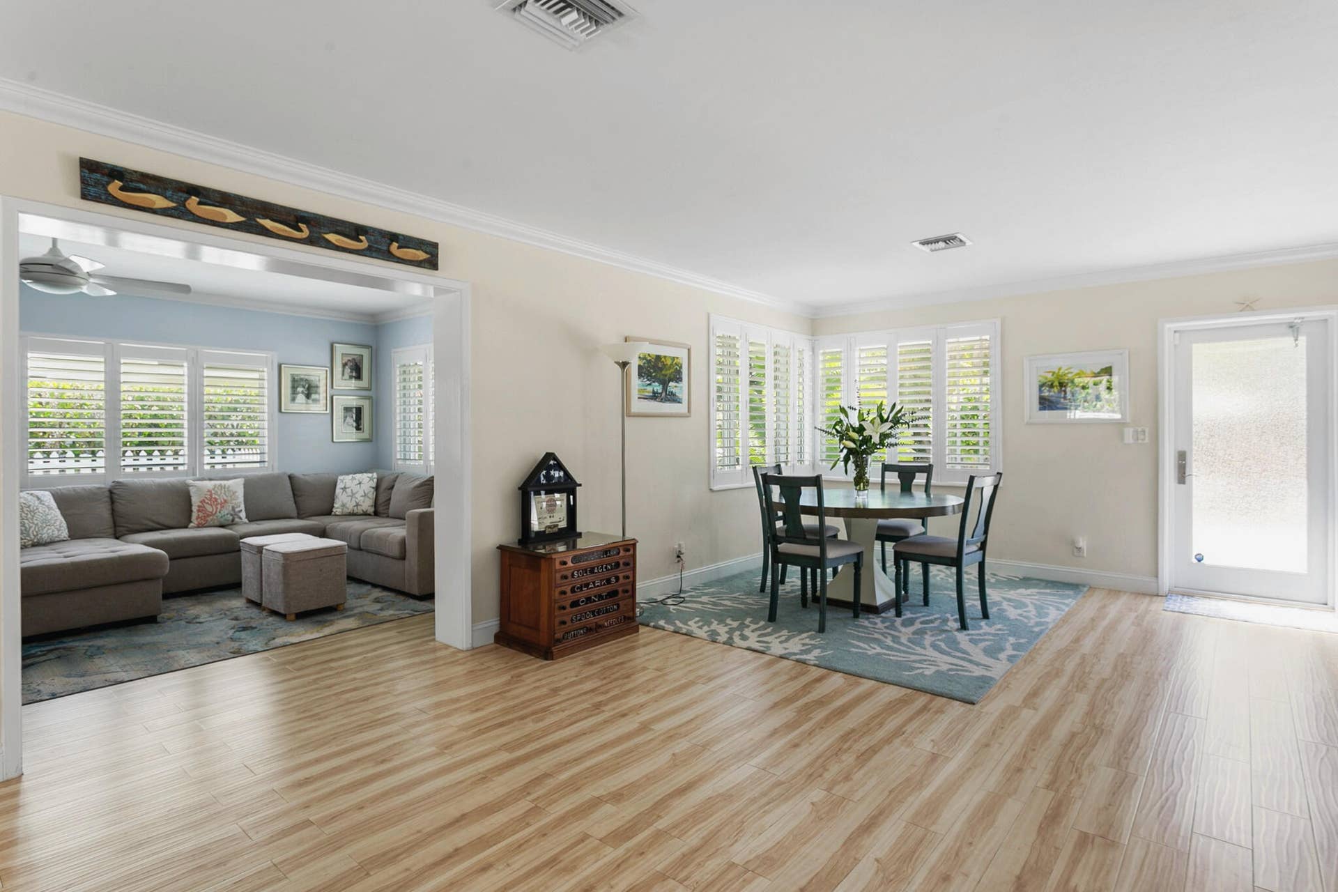 2607 SE 21ST Street, Fort Lauderdale, FL 33316 Open-concept living space featuring wood-finish flooring, plantation shutters, crown molding, and a partial wall partition