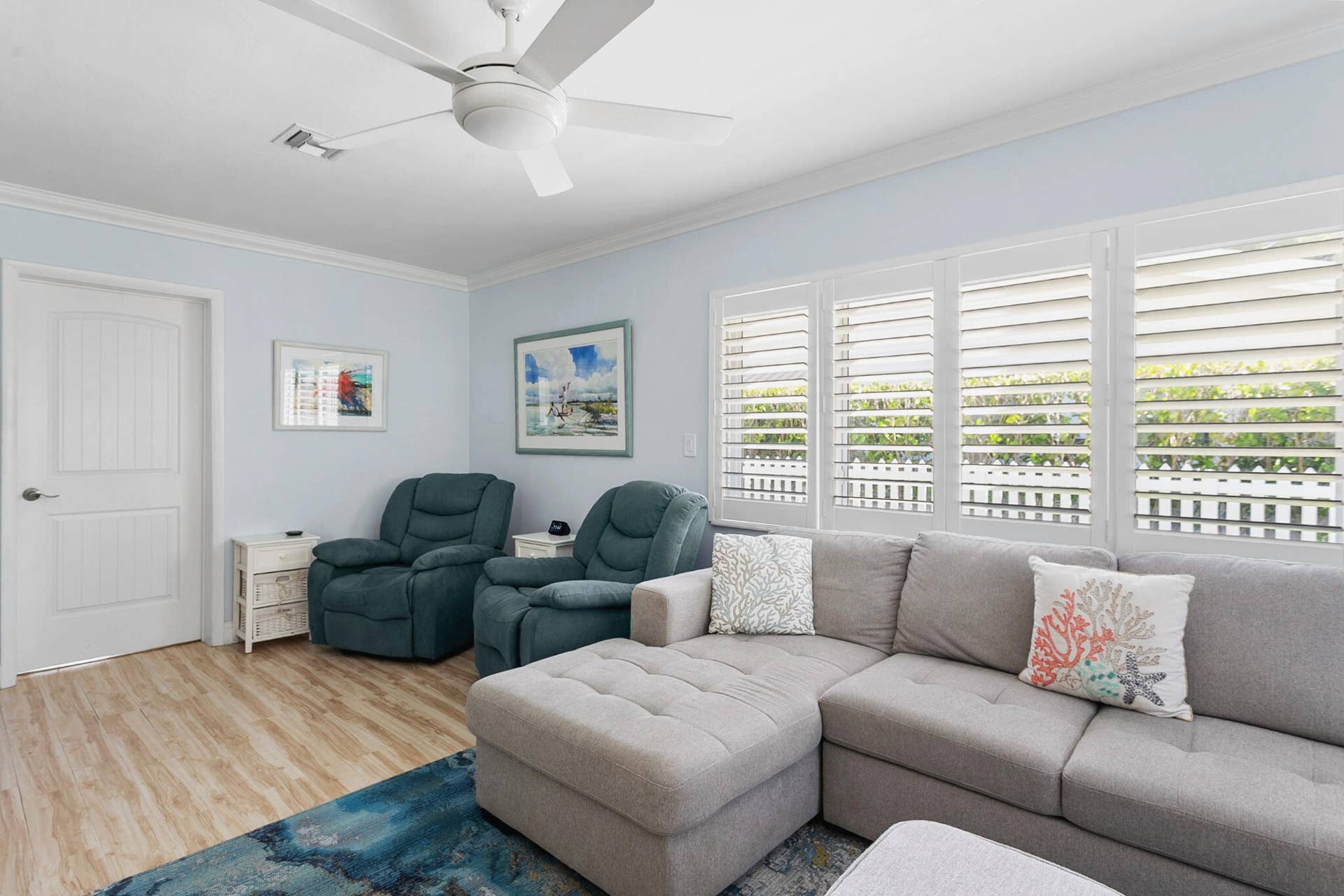 2607 SE 21ST Street, Fort Lauderdale, FL 33316 Light-filled living room featuring wood-finish flooring, plantation shutters, and a ceiling fan