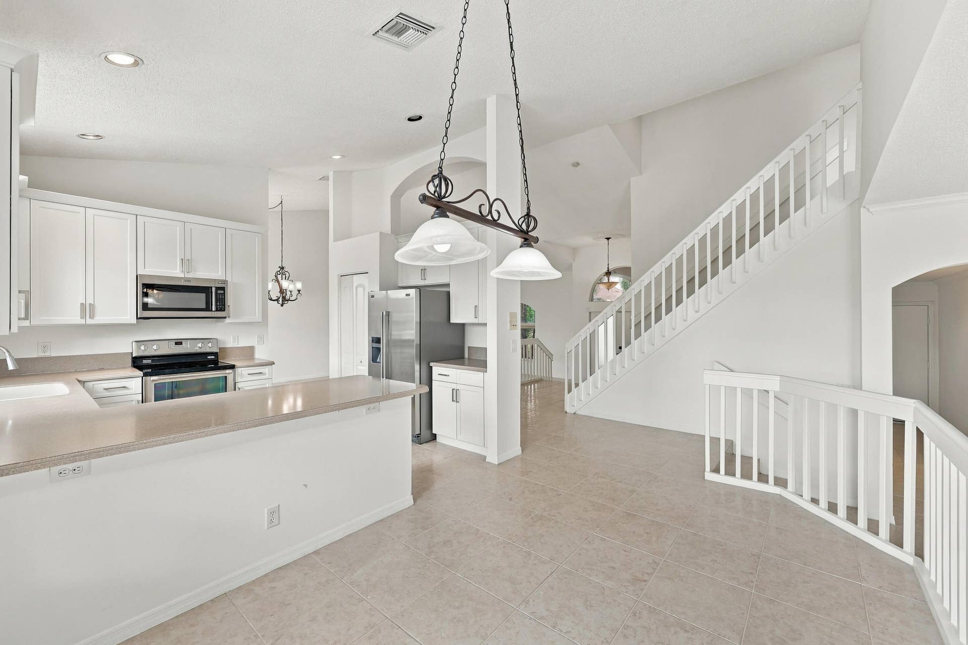 10671 St Thomas Drive, Boca Raton, FL 33498 An inviting kitchen and breakfast area featuring white cabinetry, generous counter space, and an open design that connects seamlessly to the surrounding living areas.