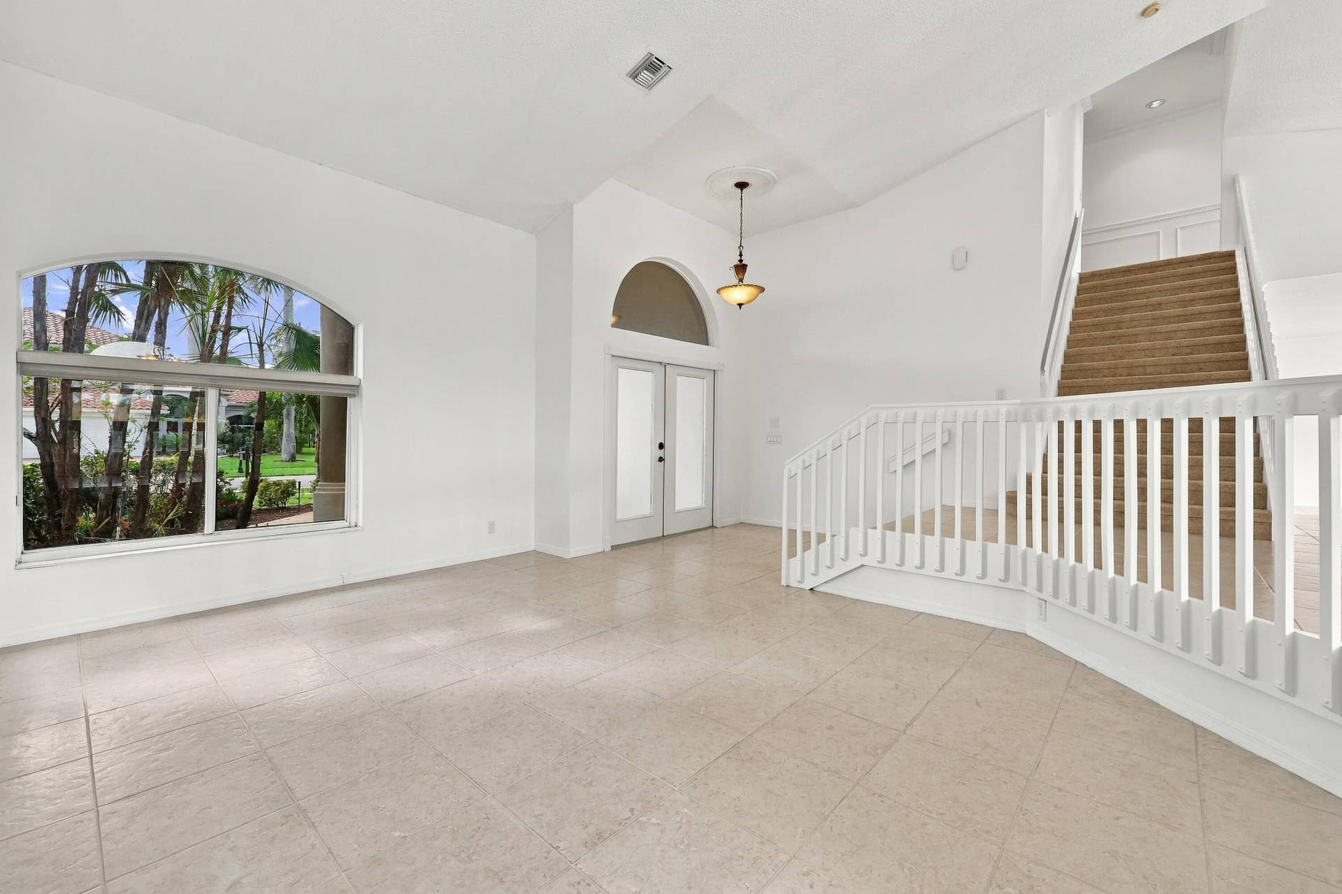 10671 St Thomas Drive, Boca Raton, FL 33498 Impressive formal living room with dramatic vaulted ceilings, oversized arched windows, and an open, airy design that creates a wonderful first impression.