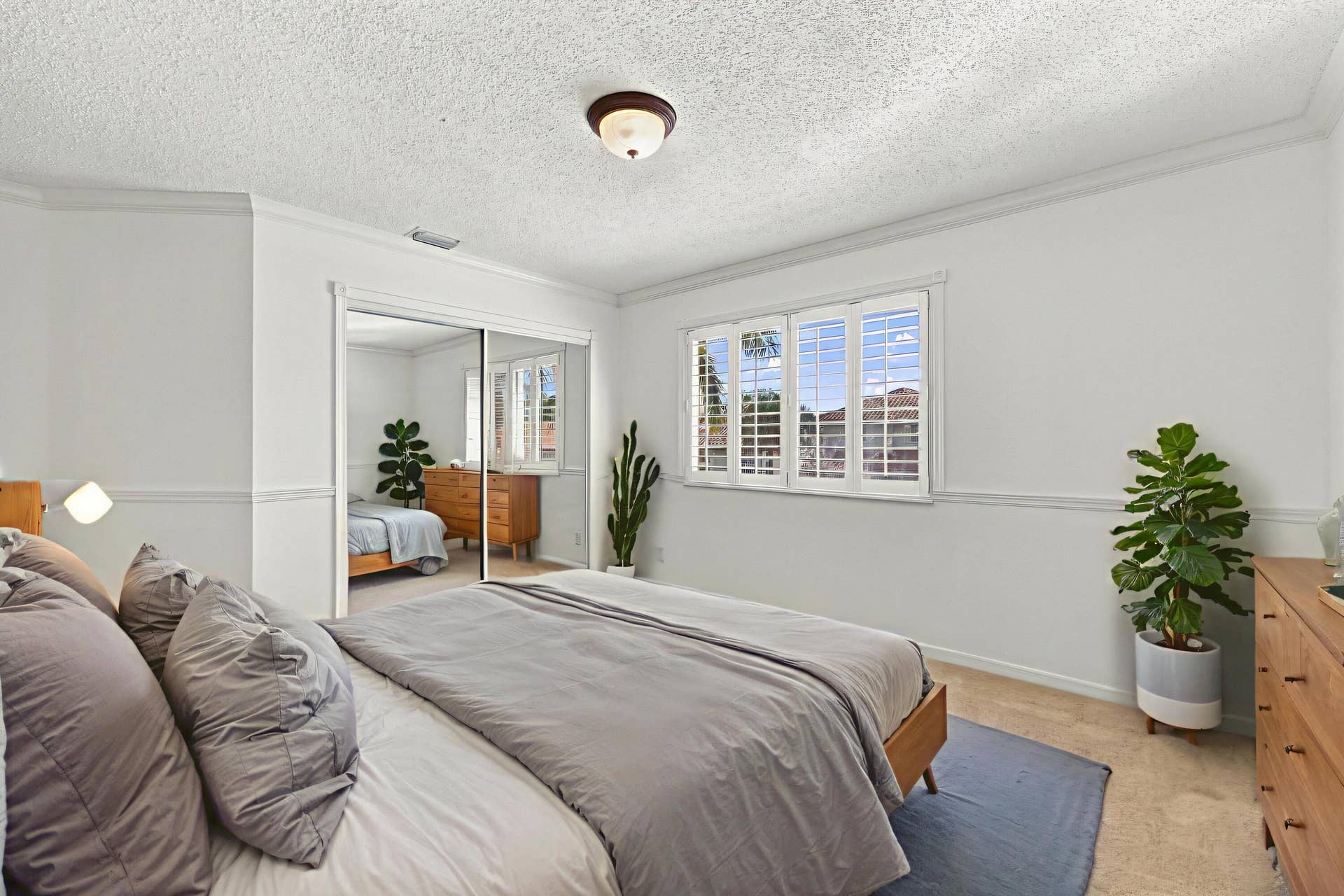 10671 St Thomas Drive, Boca Raton, FL 33498 This generously sized third bedroom features plush carpeting, plantation shutters, mirrored closet doors, and decorative wall molding that adds character.
