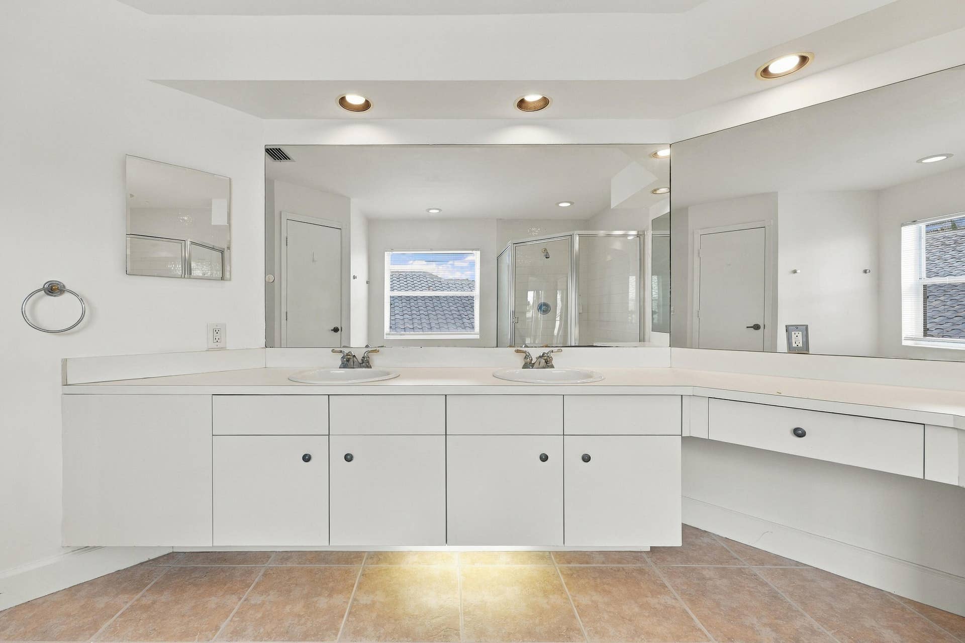 10671 St Thomas Drive, Boca Raton, FL 33498 An impressive primary bathroom featuring an extended vanity with abundant cabinetry, expansive mirrors, recessed lighting, and a dedicated makeup station.