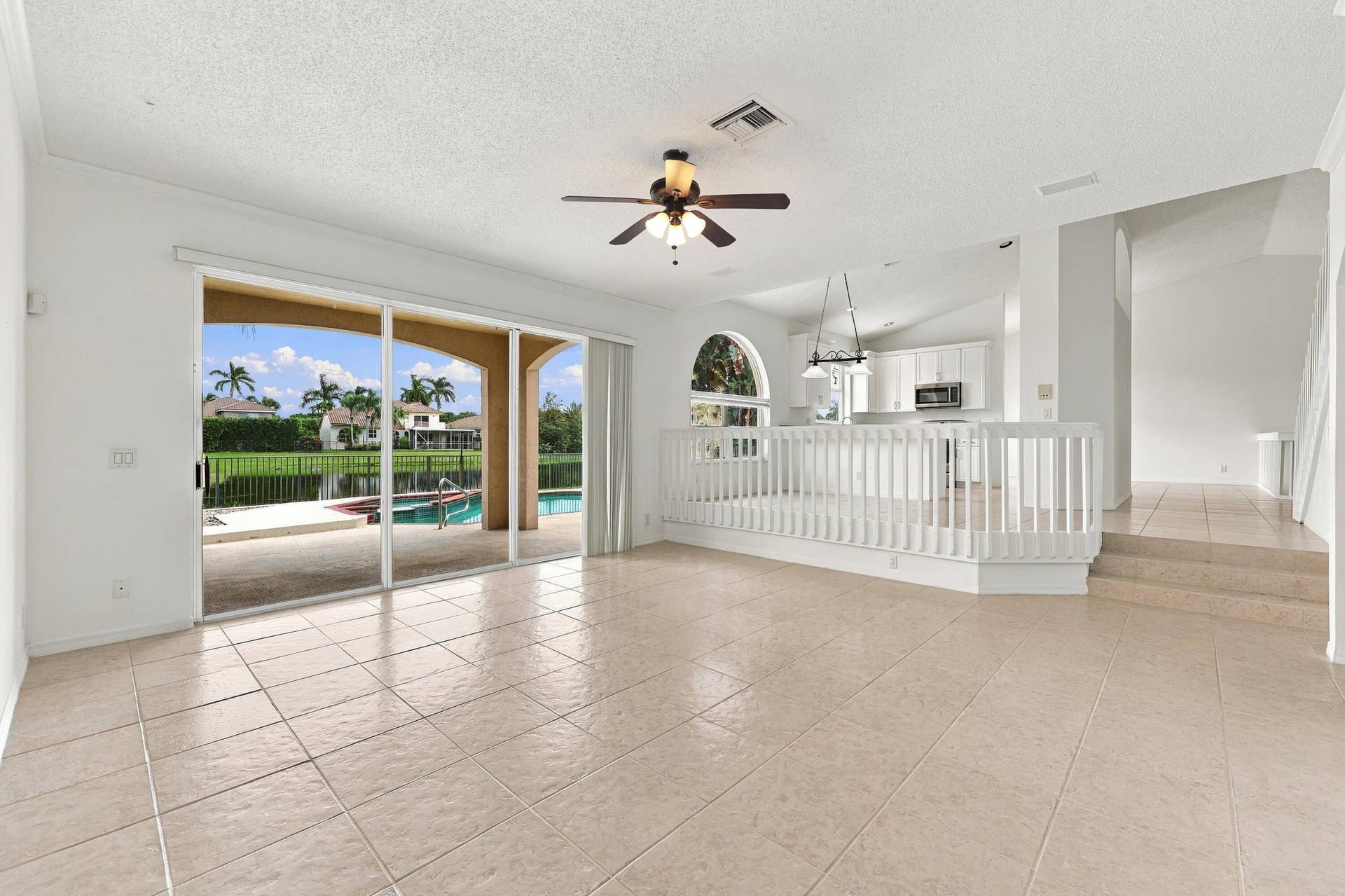 10671 St Thomas Drive, Boca Raton, FL 33498 The generous formal living room offers soaring ceilings, an elegant chandelier, and an open design overlooking the home's grand entryway.
