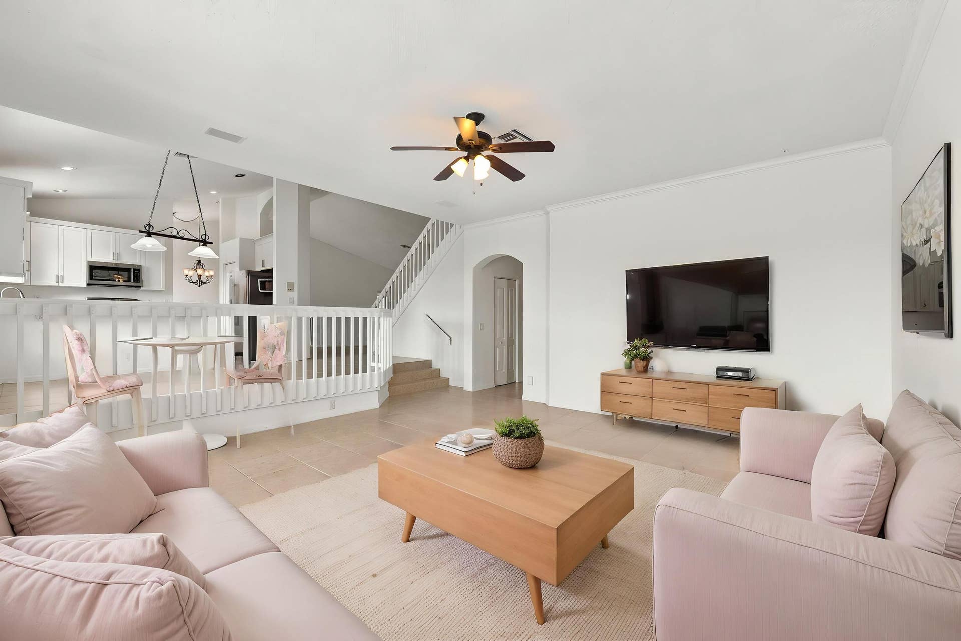 10671 St Thomas Drive, Boca Raton, FL 33498 The generous formal living room offers soaring ceilings, an elegant chandelier, and an open design overlooking the home's grand entryway.