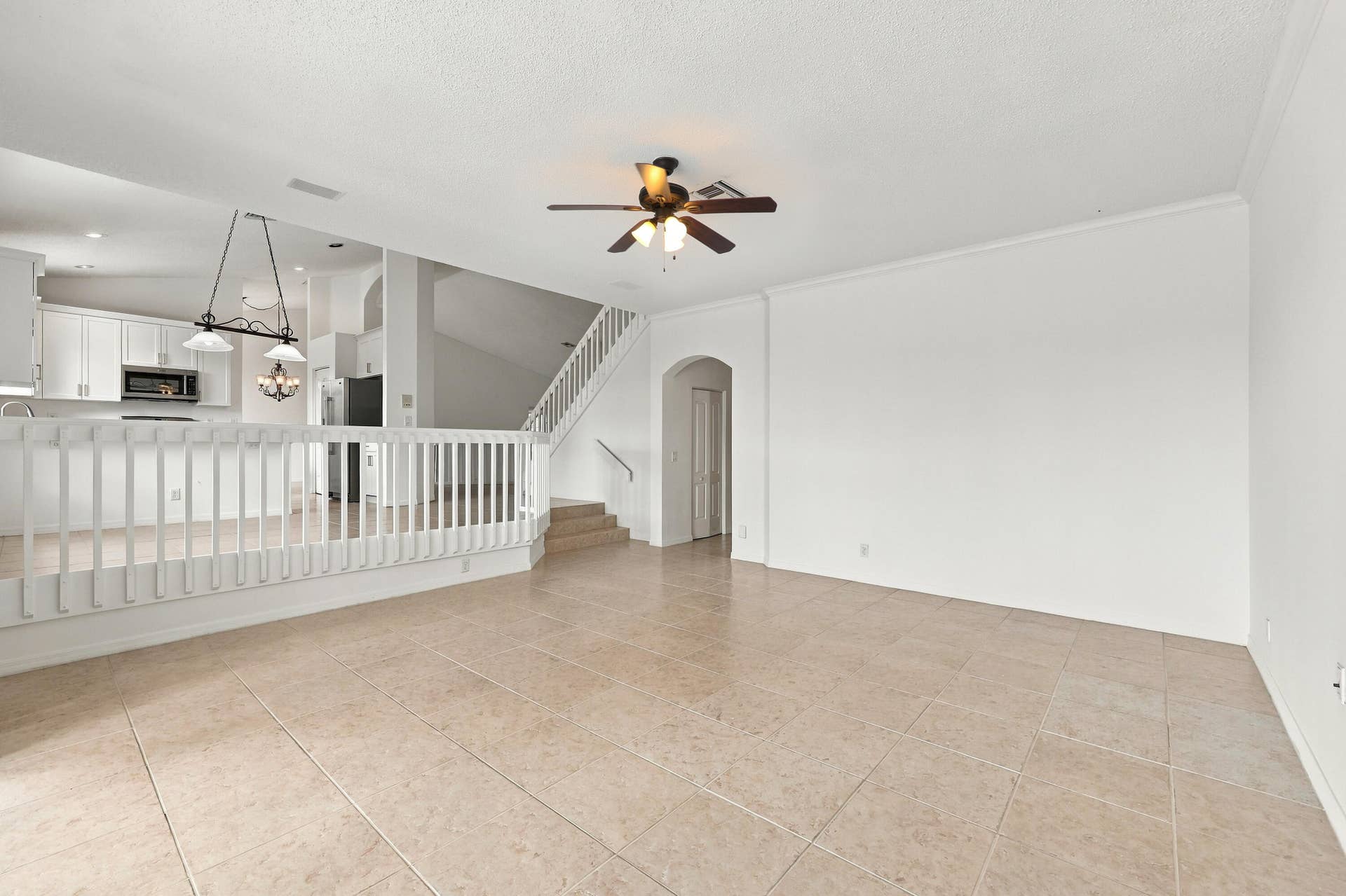 10671 St Thomas Drive, Boca Raton, FL 33498 The generous formal living room offers soaring ceilings, an elegant chandelier, and an open design overlooking the home's grand entryway.