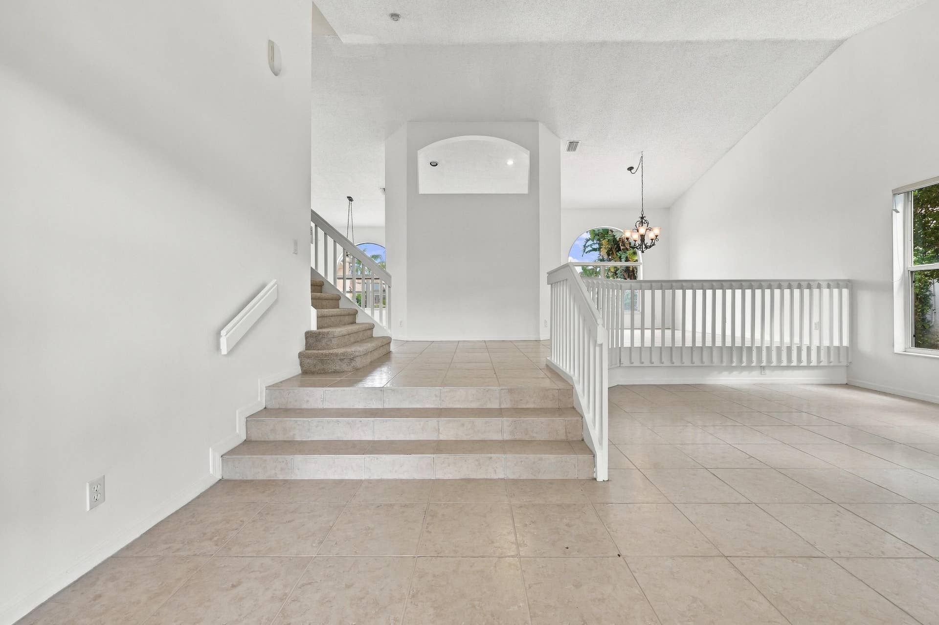 10671 St Thomas Drive, Boca Raton, FL 33498 An elegant staircase with white railings complements the home's spacious, multi-level design, creating an inviting transition between living spaces.