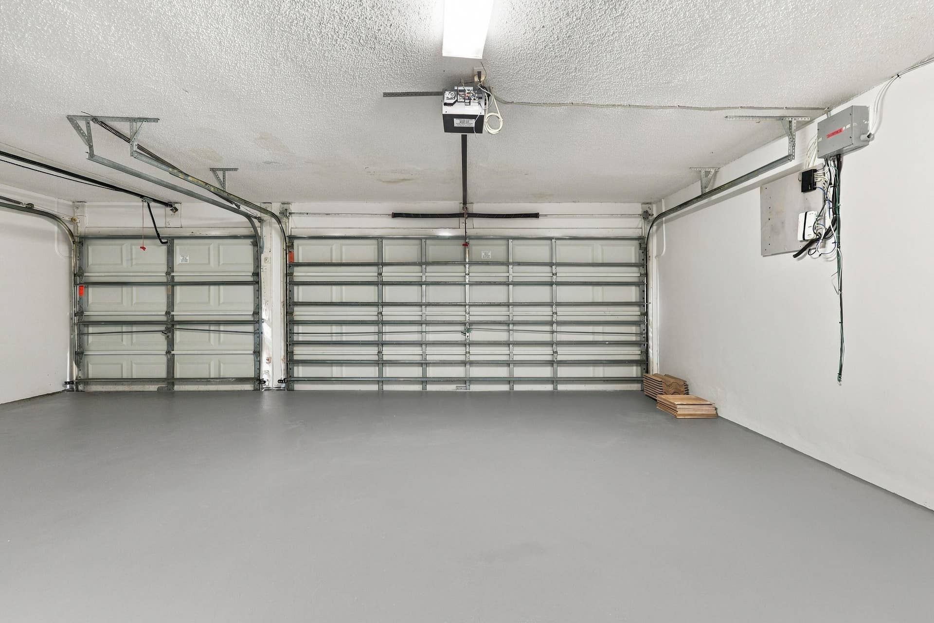 10671 St Thomas Drive, Boca Raton, FL 33498 An impressive three-car garage featuring a finished floor, multiple overhead doors, and exceptional room for vehicles, recreational equipment, and additional storage.