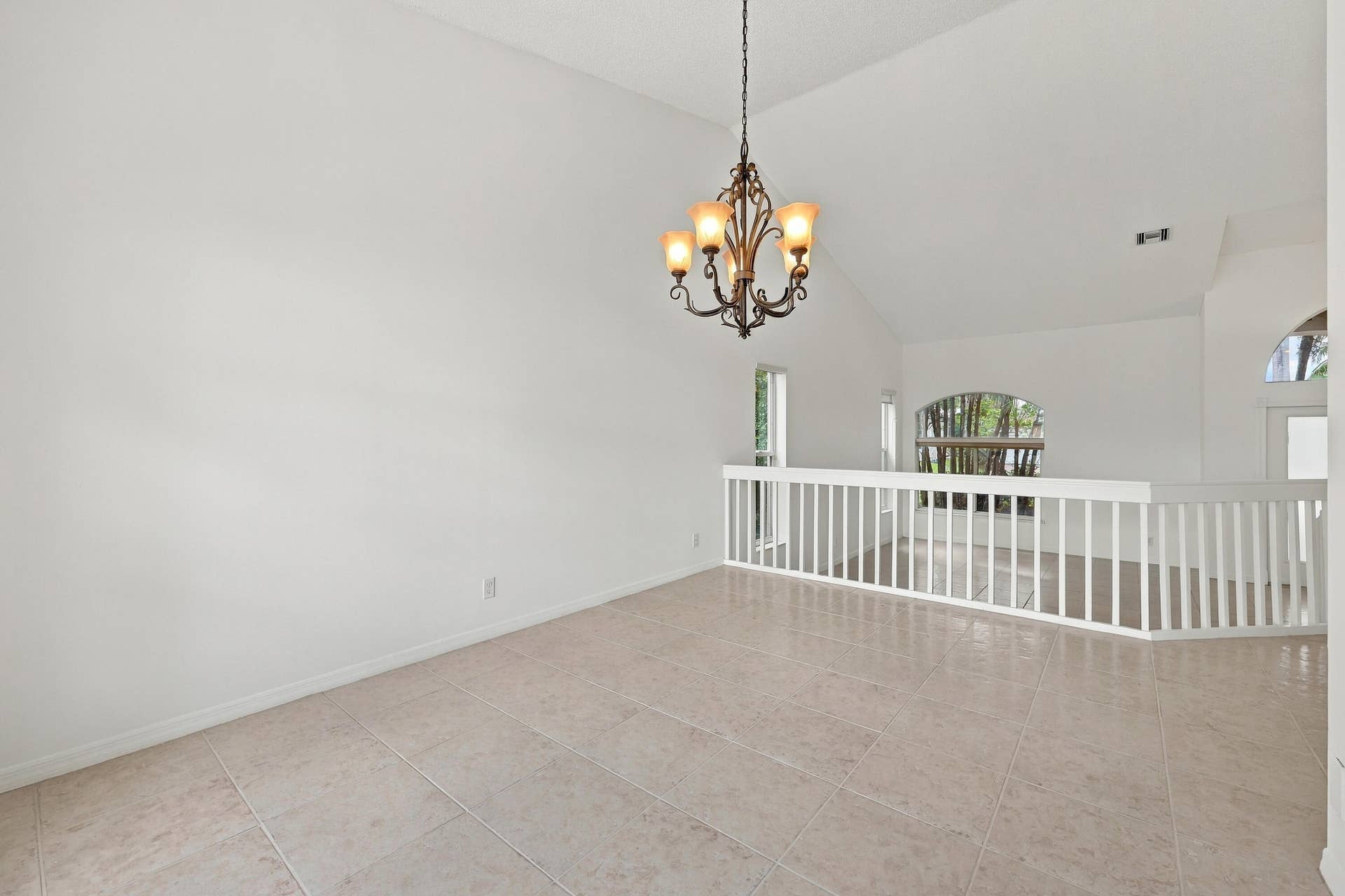 10671 St Thomas Drive, Boca Raton, FL 33498 A decorative chandelier, dramatic arched window, and vaulted ceilings provide an elegant setting for both intimate dinners and larger celebrations.