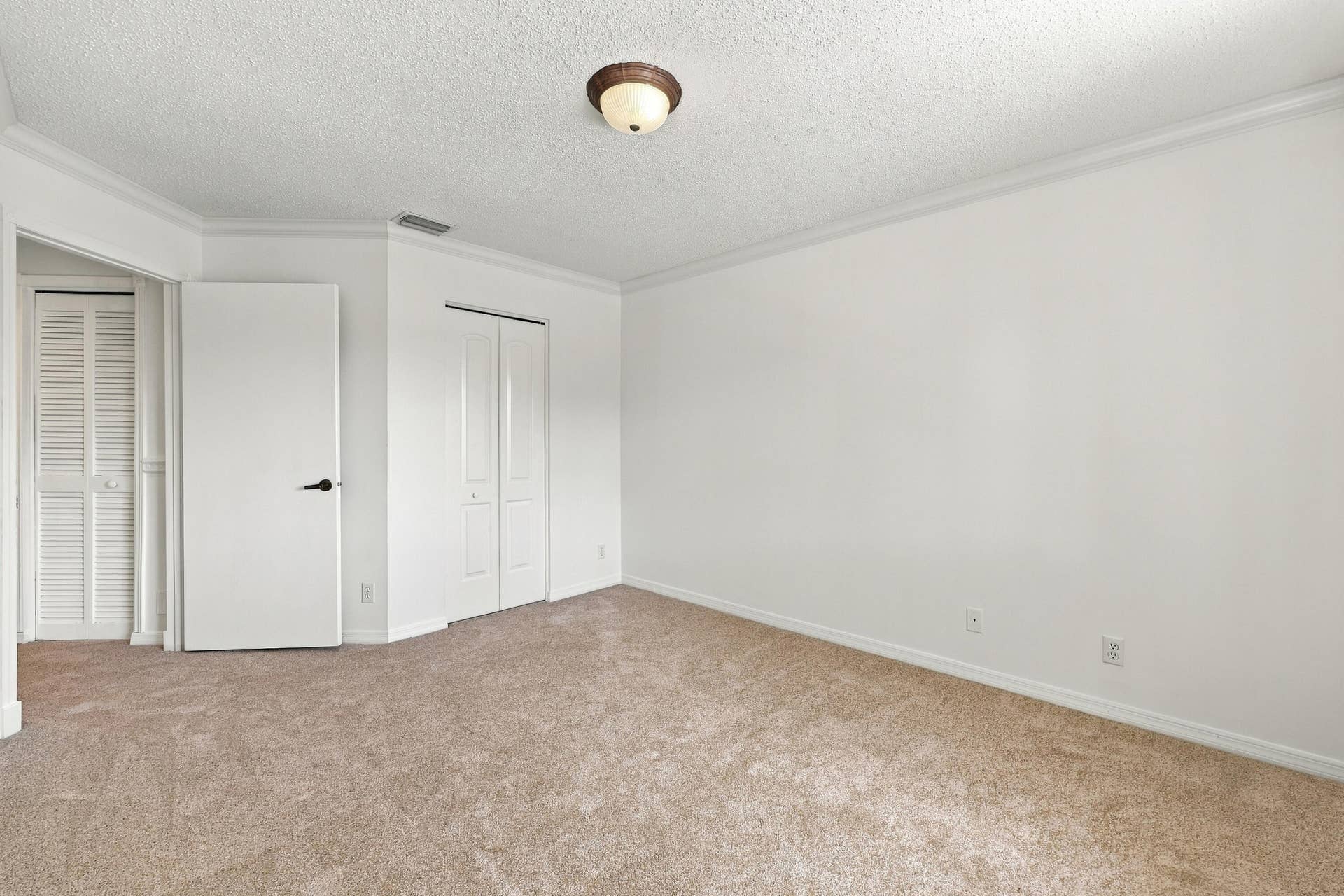 10671 St Thomas Drive, Boca Raton, FL 33498 This inviting fourth bedroom features plush carpeting, neutral finishes, decorative crown molding, and a generous layout offering plenty of flexibility.